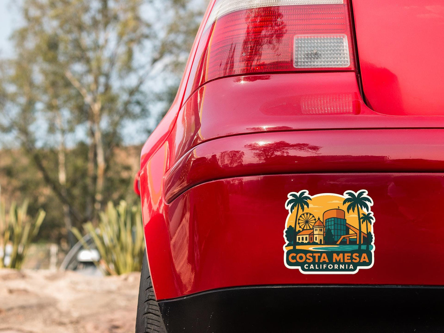 the rear end of a red car with a sticker on the trunk that says "Costa Mesa, California".