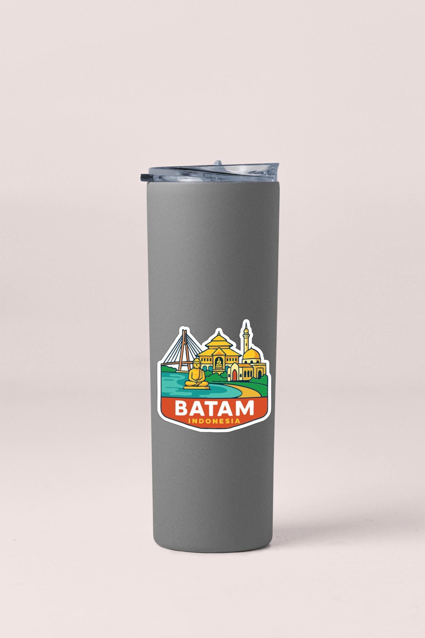 A gray insulated tumbler with a sticker depicting the city of Batam, Indonesia.
