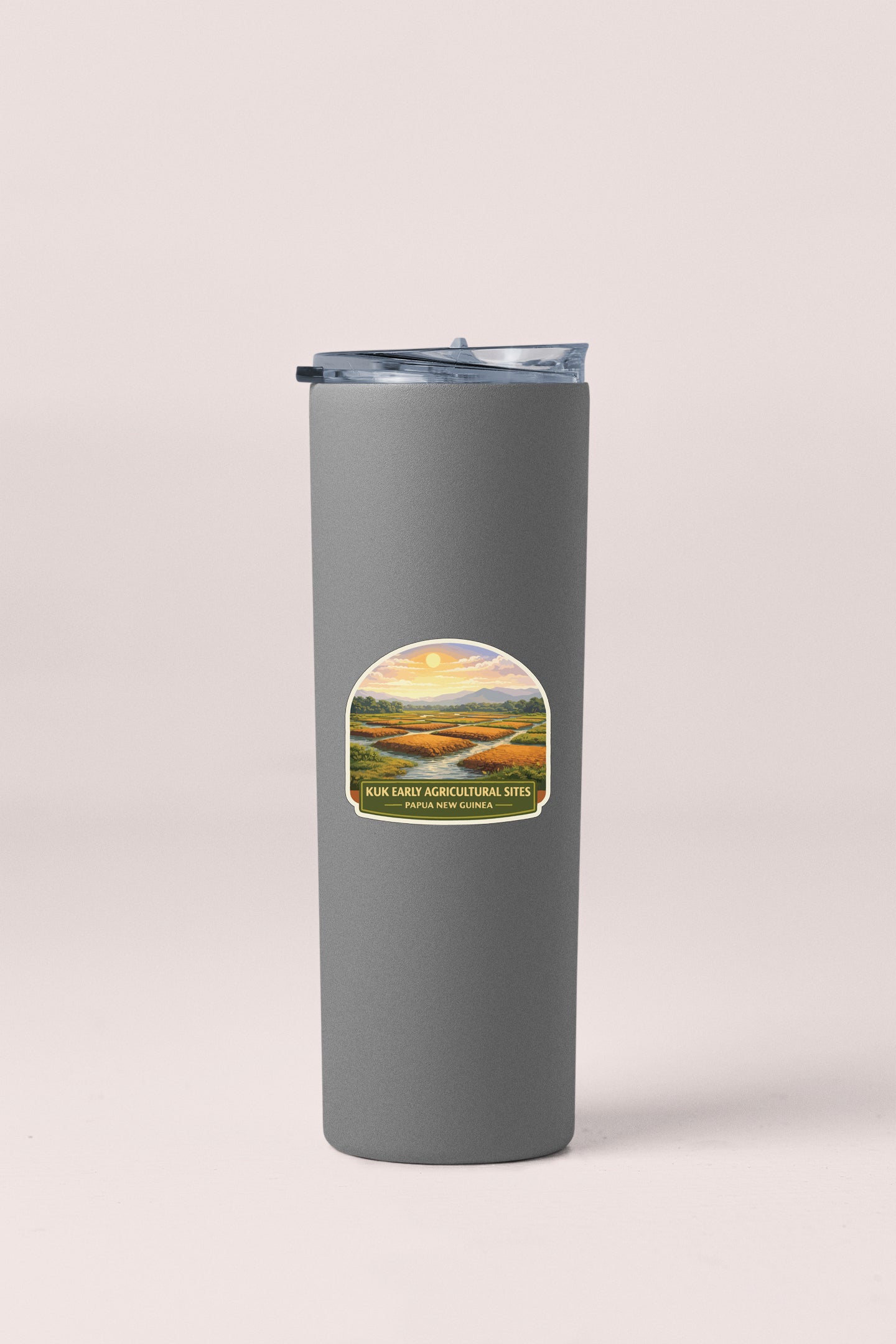 A gray insulated tumbler with a label depicting a scenic landscape.