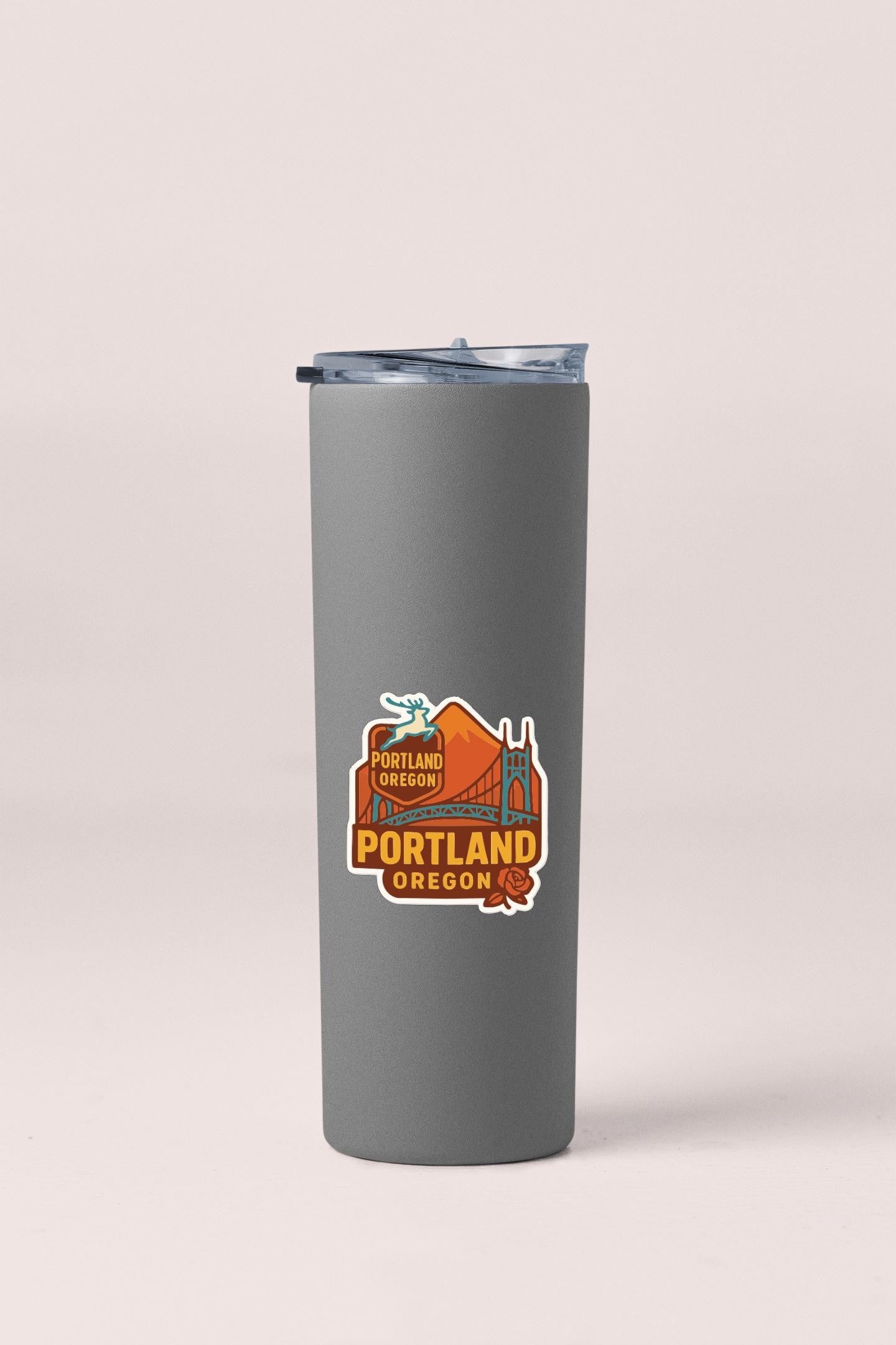 A gray insulated tumbler with a sticker depicting the Portland, Oregon skyline.