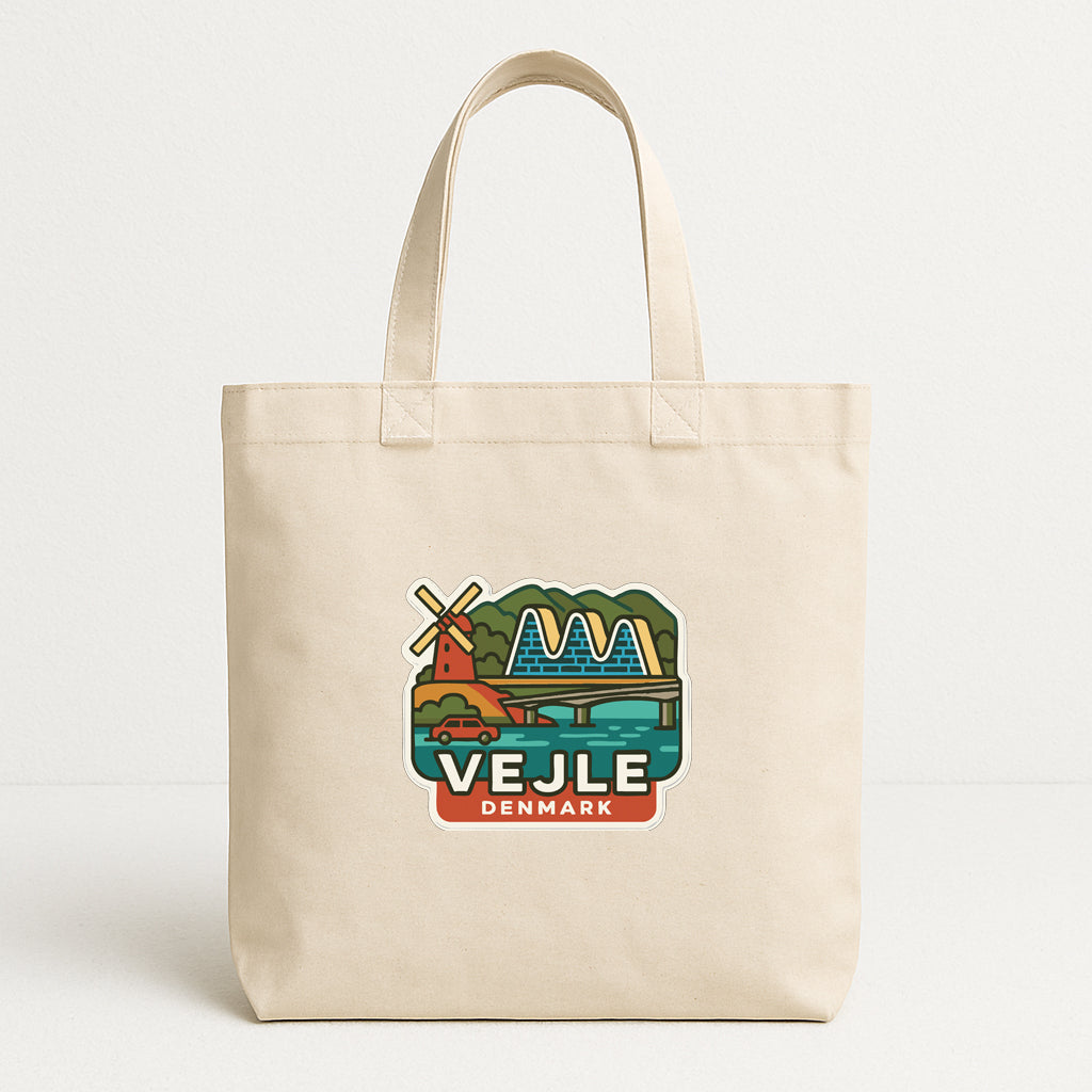 A beige tote bag with a graphic design depicting a windmill and a body of water, along with the text "VEJLE DENMARK".