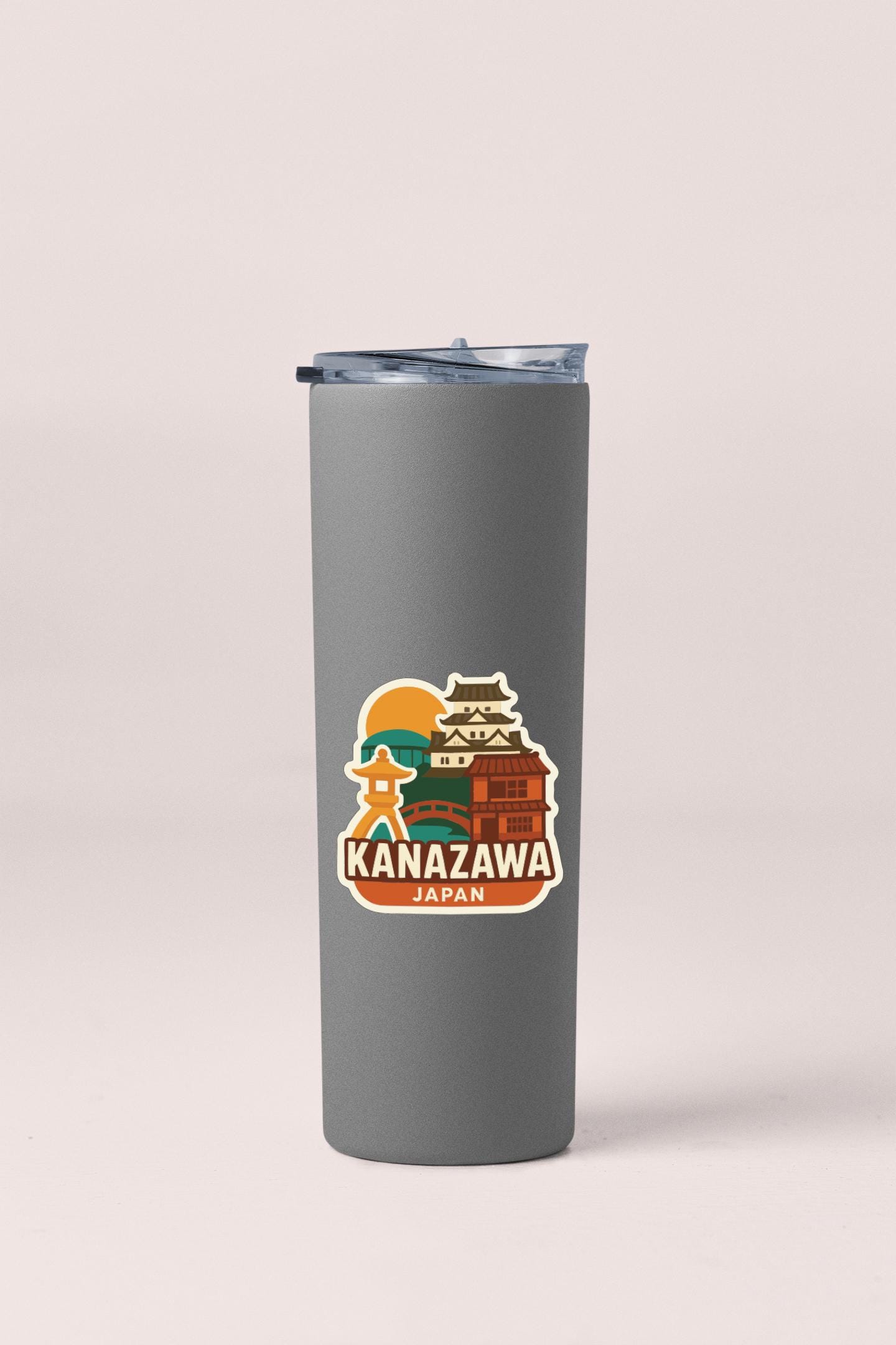 A gray insulated tumbler with a sticker depicting the Kanazawa Castle in Japan.