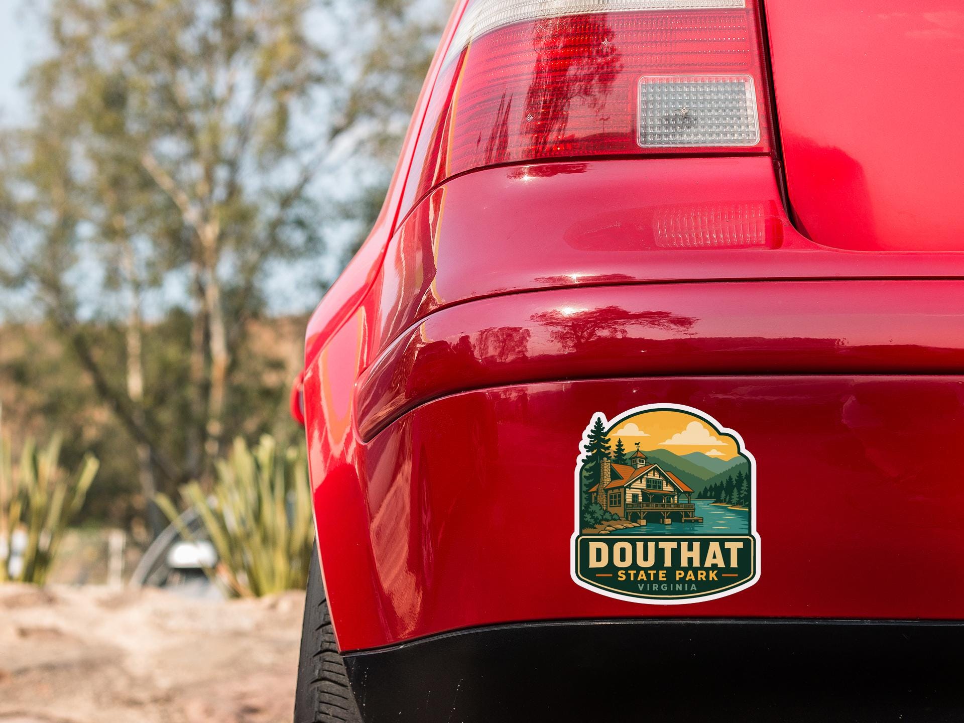 the rear end of a red car with a sticker on the trunk that says "DOUTHAT STATE PARK VIRGINIA".