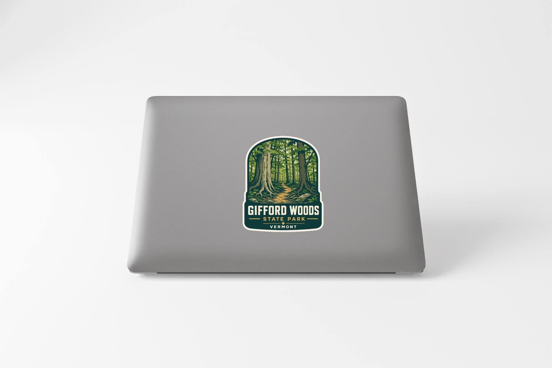 a sticker with a forest scene on a laptop.