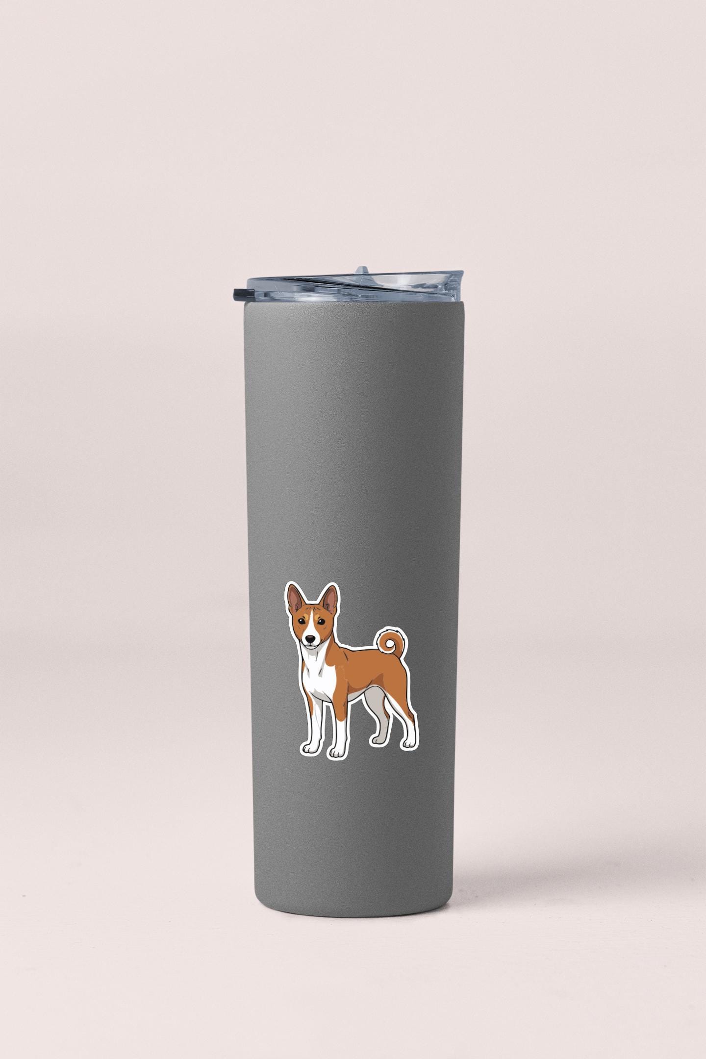 A gray insulated tumbler with a sticker of a dog on it.