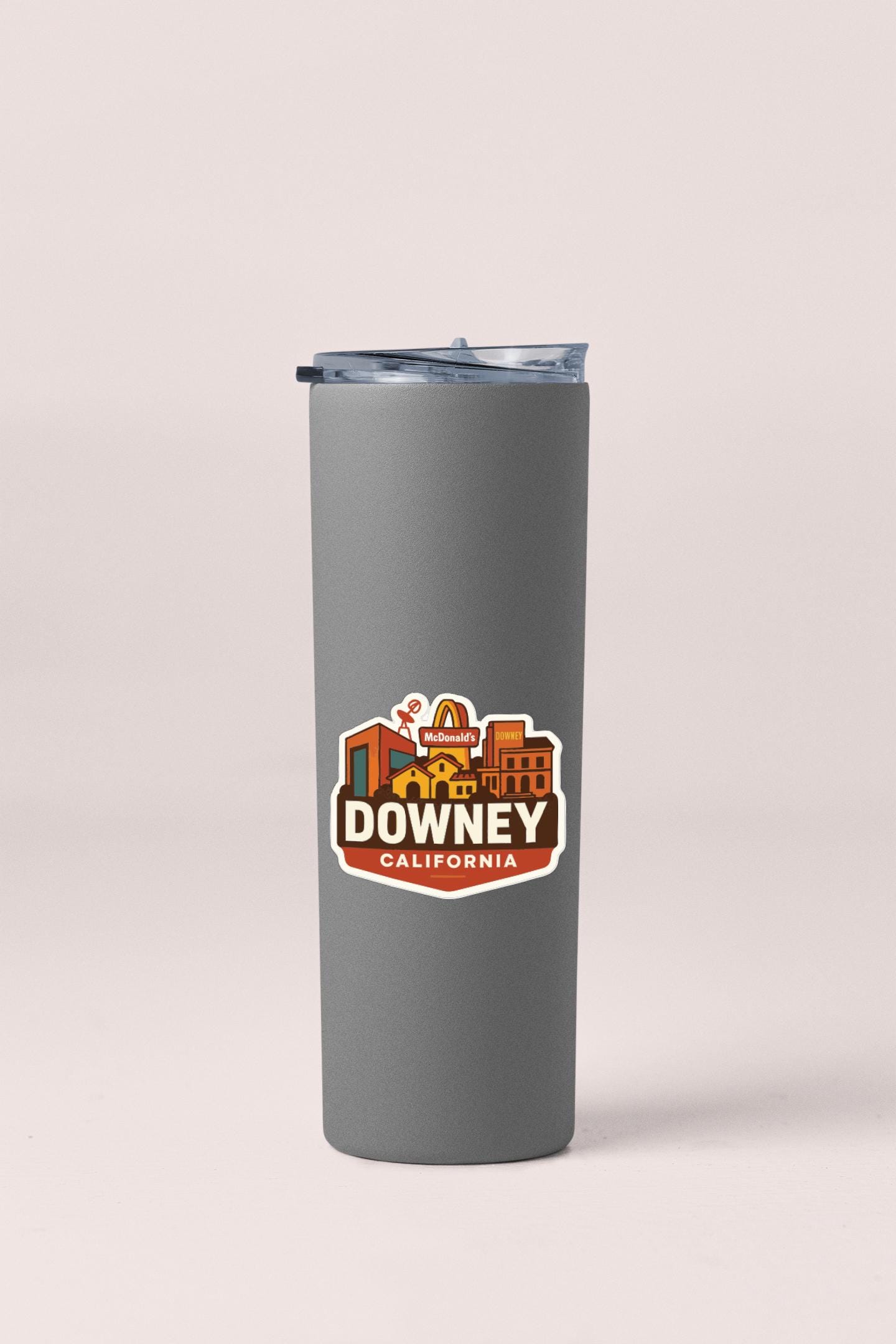 A gray insulated tumbler with a sticker featuring the city of Downey, California.
