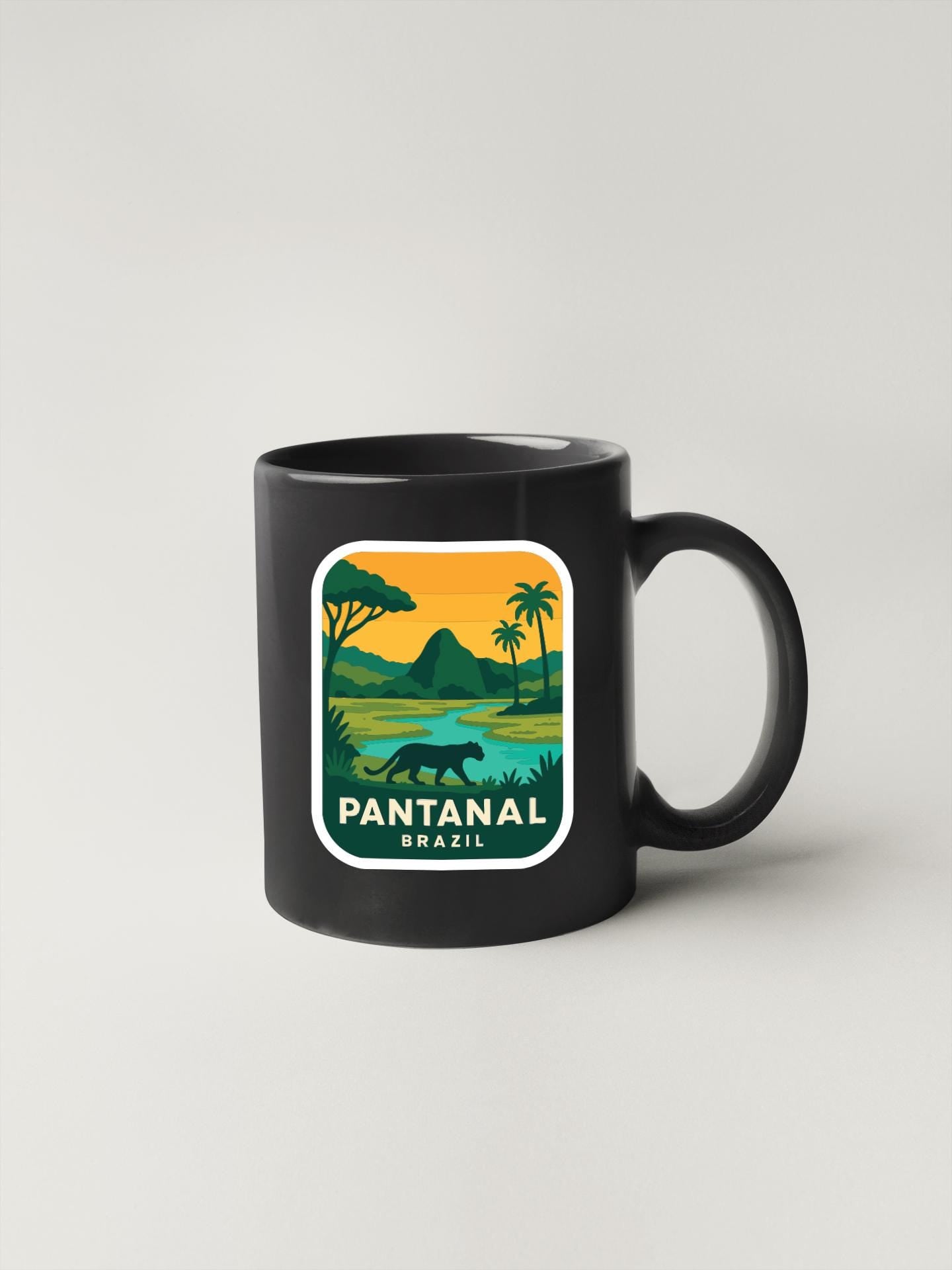 A black coffee mug with a graphic design depicting a tropical landscape, including palm trees, a river, and a panther.