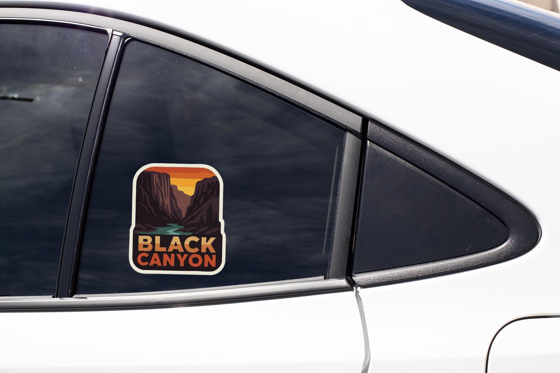 A sticker on the side of a car window that says "BLACK CANYON".