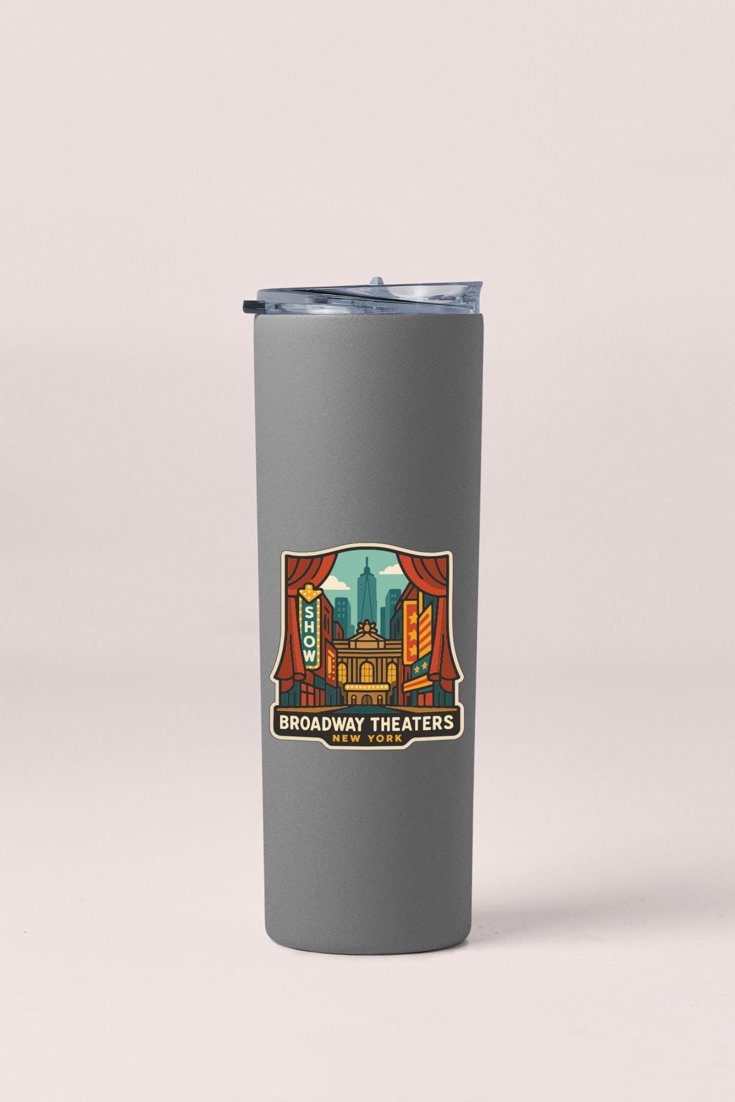 A gray tumbler with a label featuring an illustration of the Broadway Theaters in New York.