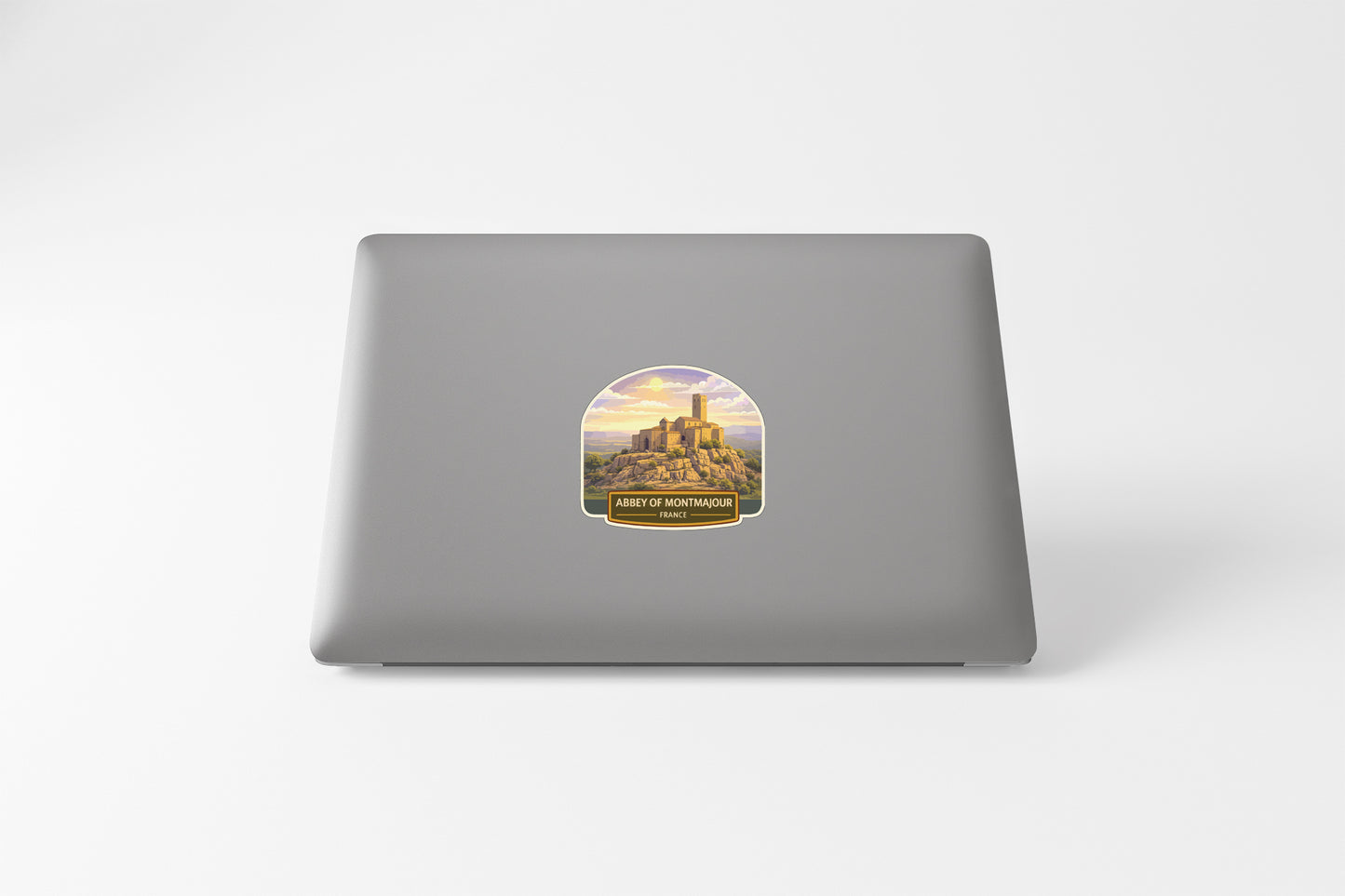 a sticker with a castle on it, placed on the back of a laptop.