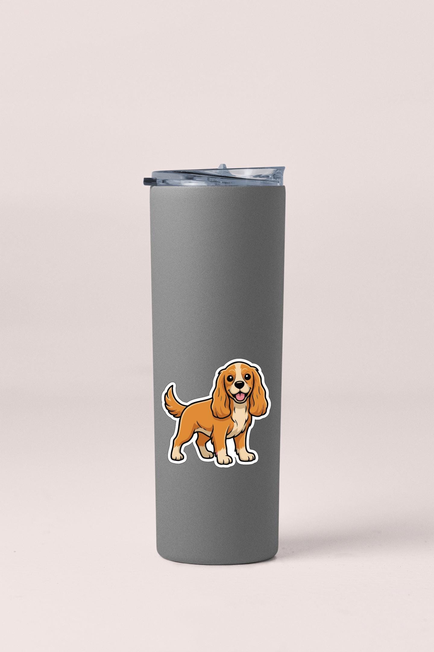 A gray insulated tumbler with a cartoon dog sticker on it.