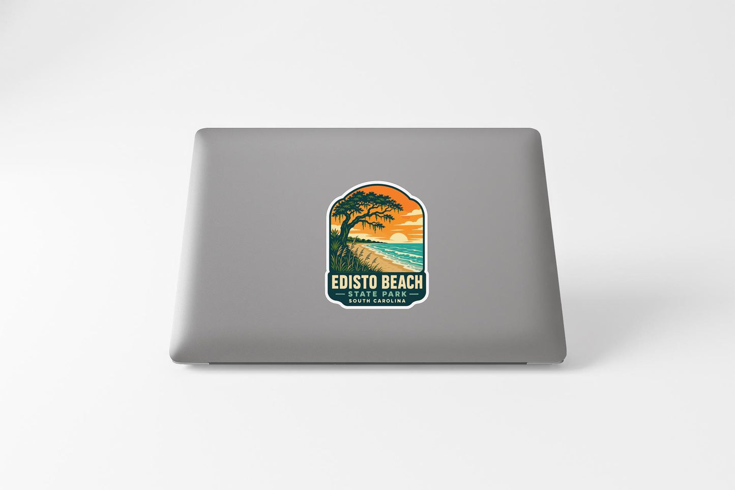 A sticker on the back of a laptop, depicting a scenic landscape with a beach and palm trees.