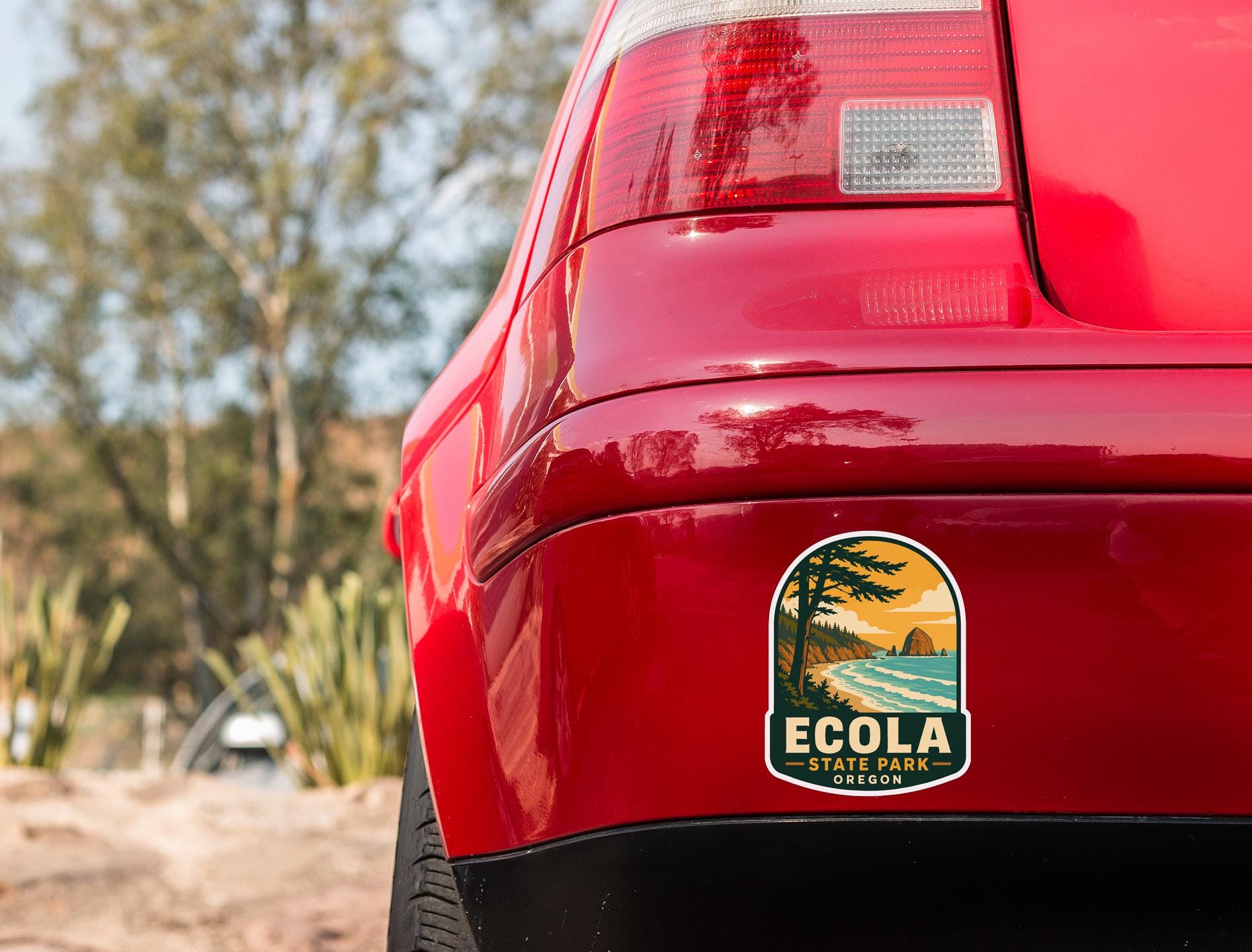 the rear end of a red car with a sticker on the trunk that says "ECOLA STATE PARK OREGON".