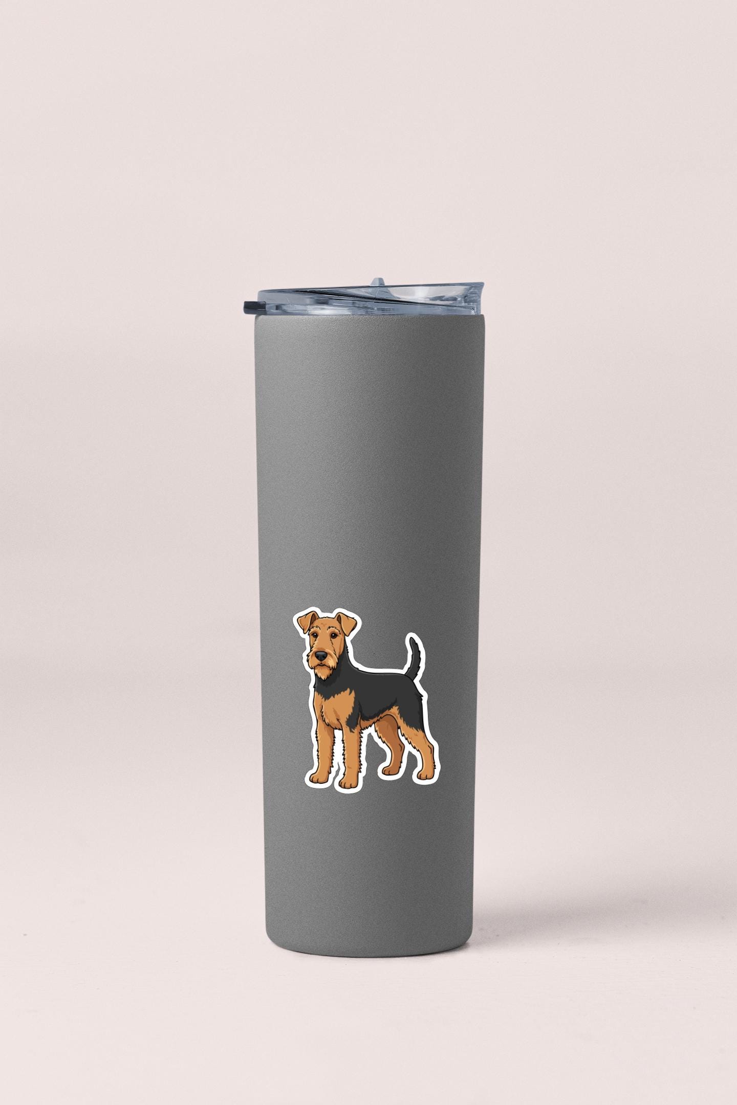A gray insulated tumbler with a sticker of a dog on it.