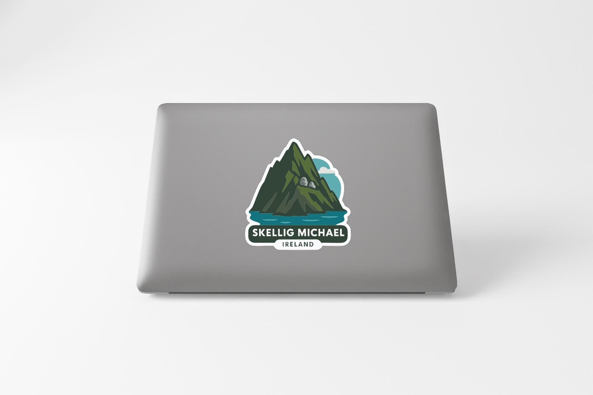 a sticker with a mountain and a lake on a laptop.