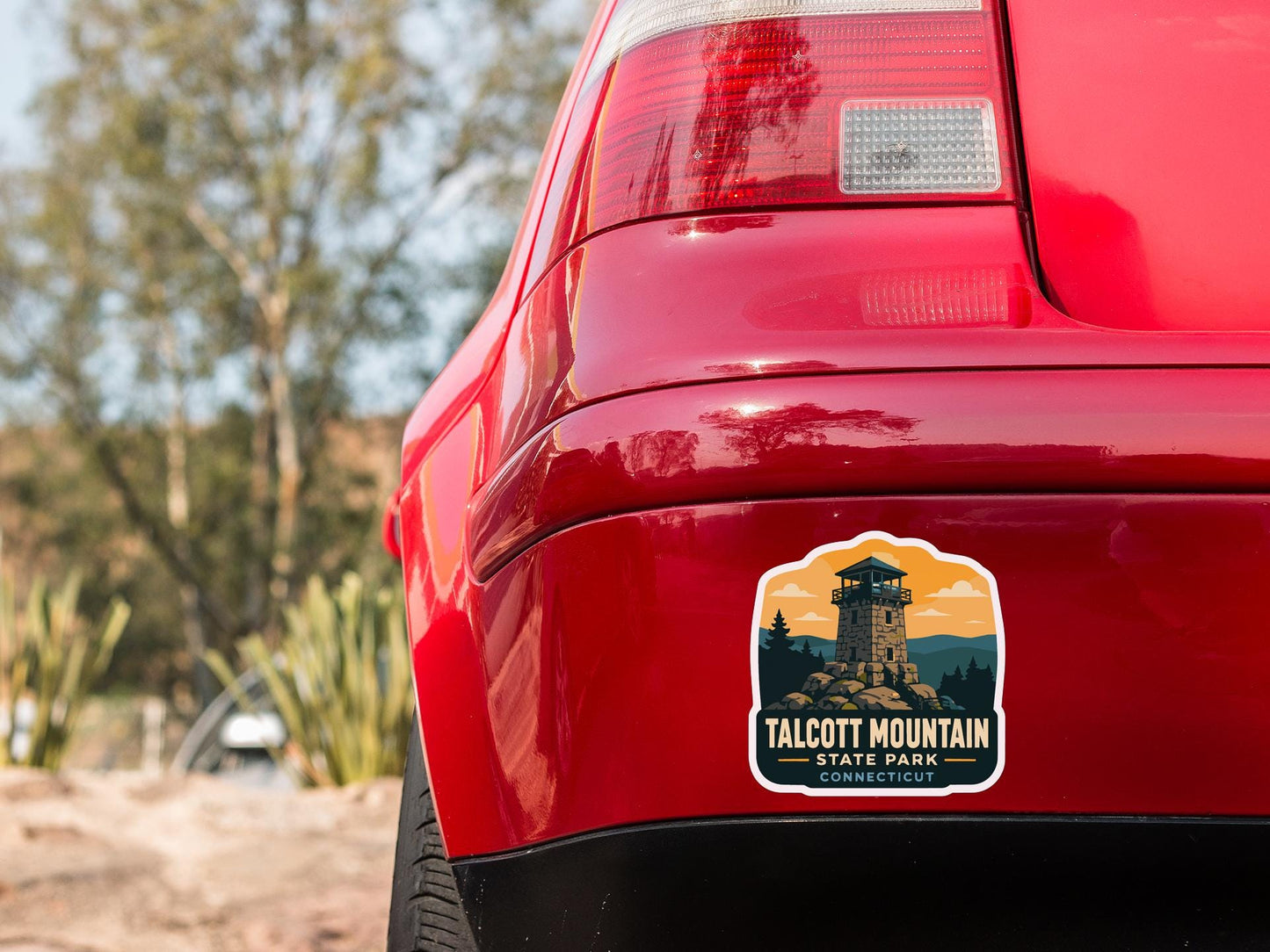 the rear end of a red car with a sticker on the trunk that says "Talcott Mountain State Park Connecticut".