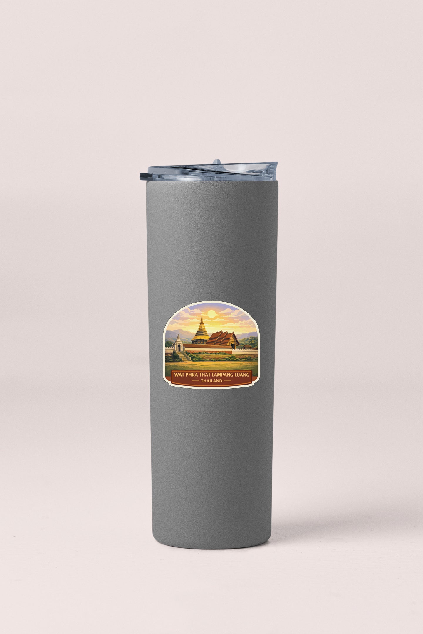 A gray insulated tumbler with a label depicting a scenic landscape.