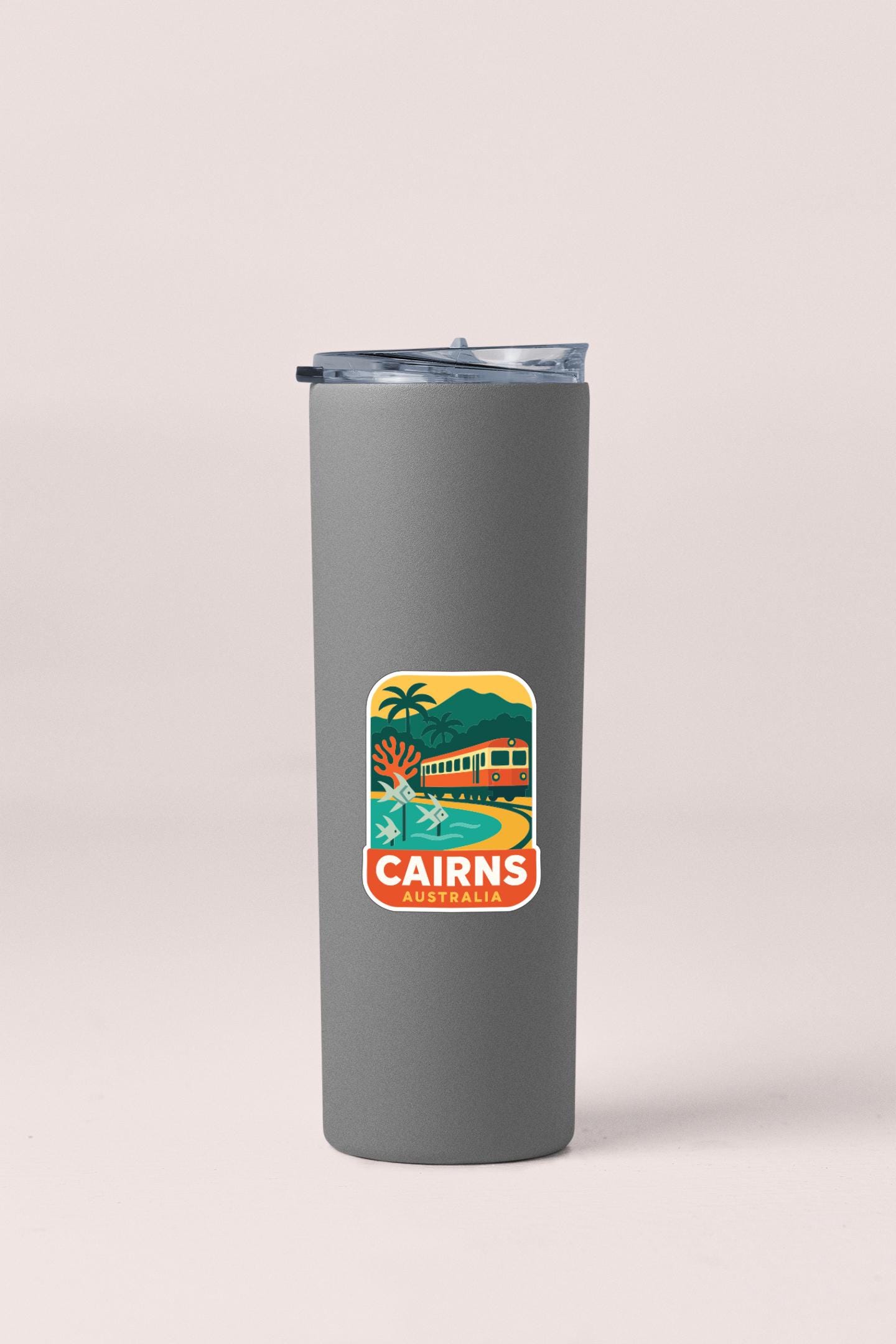 A gray insulated tumbler with a sticker depicting a scenic view of Cairns, Australia.