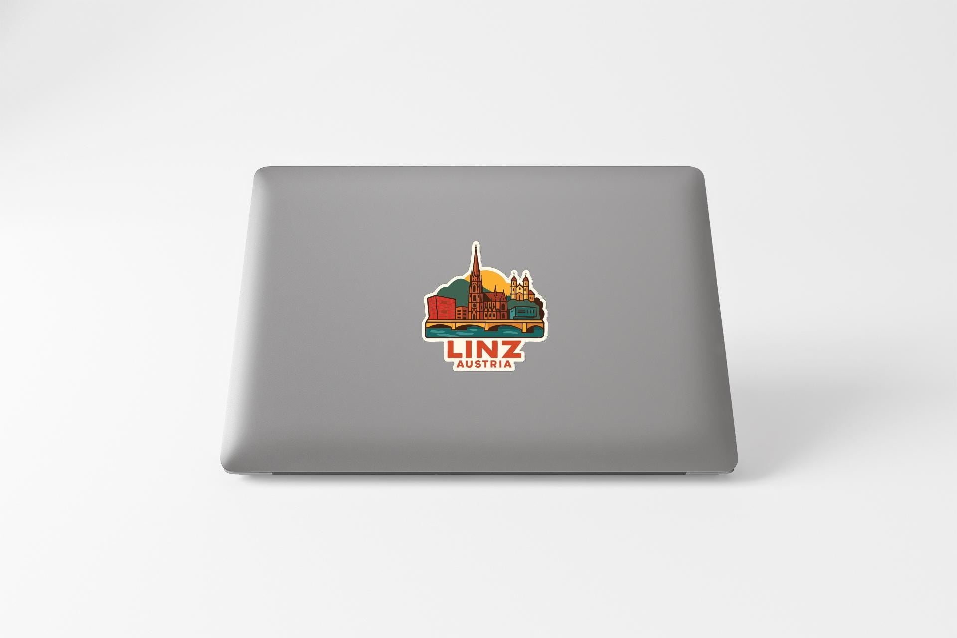 a sticker or decal of Linz, Austria, on the back of a laptop computer.
