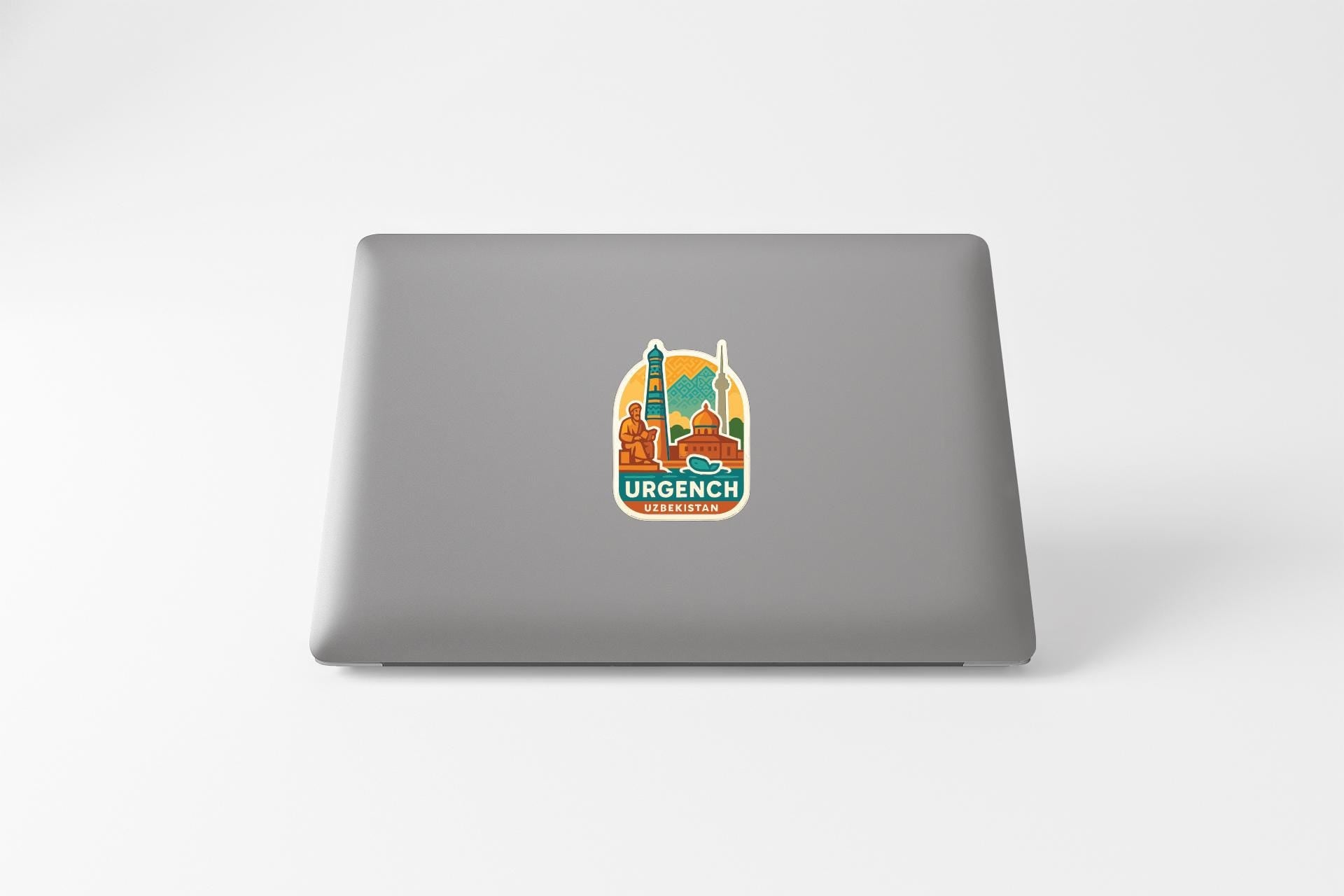 a sticker with a cityscape and the word "URGENCIA" on the back of a laptop.
