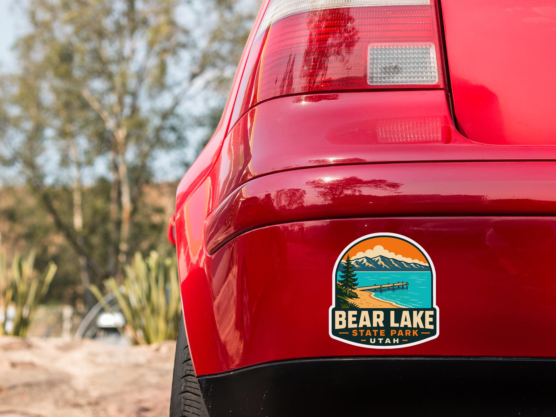 the rear end of a red car with a sticker on the back window that says "BEAR LAKE STATE PARK UTA".