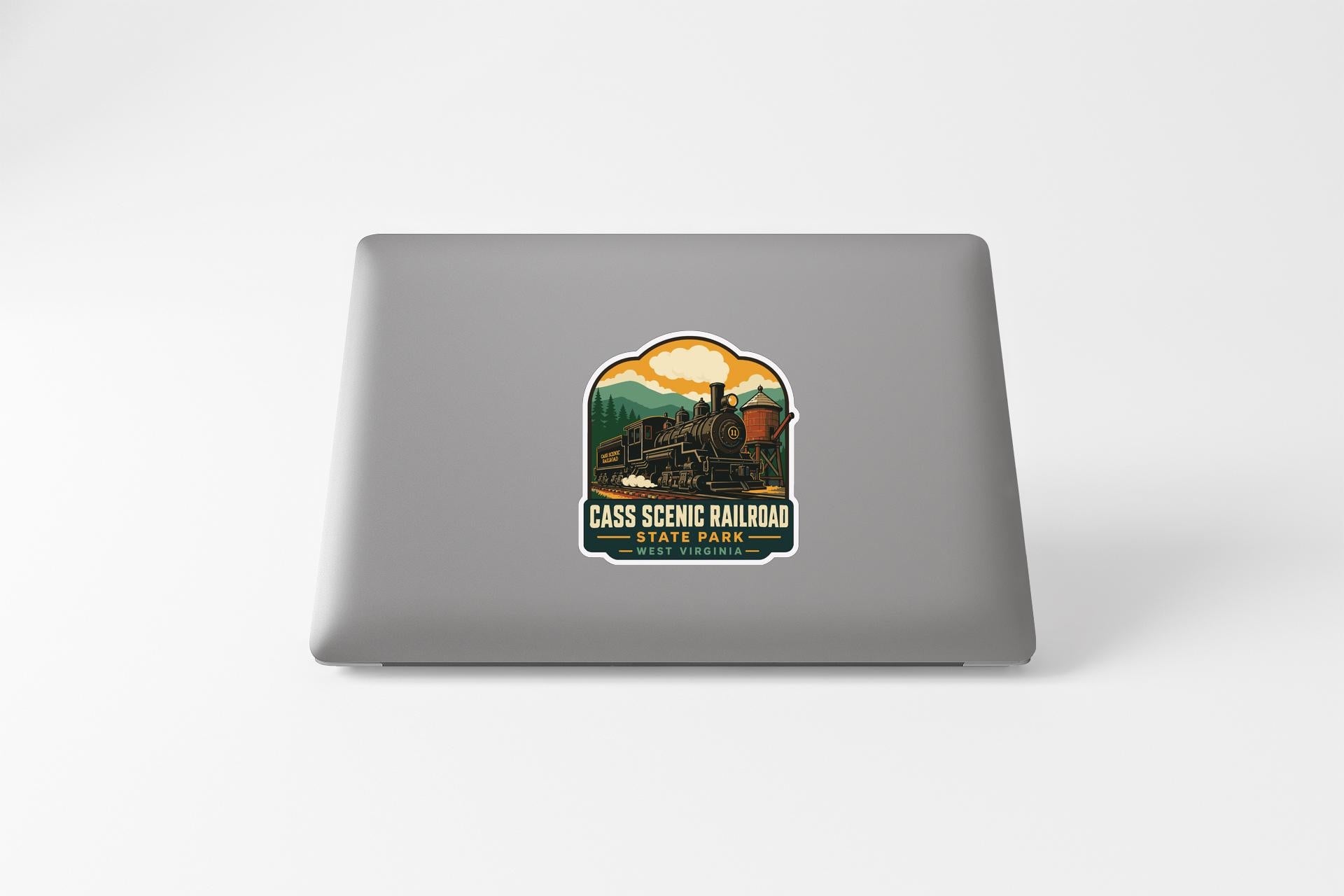 a sticker on a laptop that depicts a train, with the text "CASS SCENIC RAILROAD STATE PARK" printed on it.