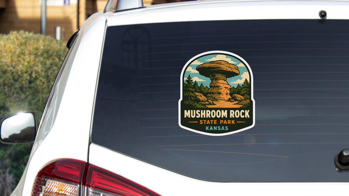 A sticker on the rear window of a white car, depicting a mushroom rock formation in Kansas State Park.