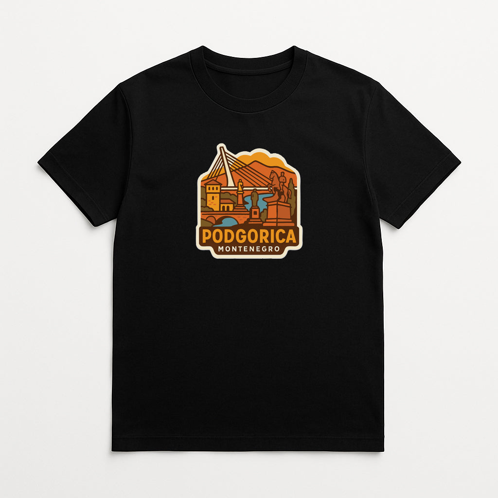 A black t-shirt with a graphic design depicting a scenic landscape with mountains, a river, and a bridge. The text "PODGORICA MONTENEGRO" is displayed below the image.