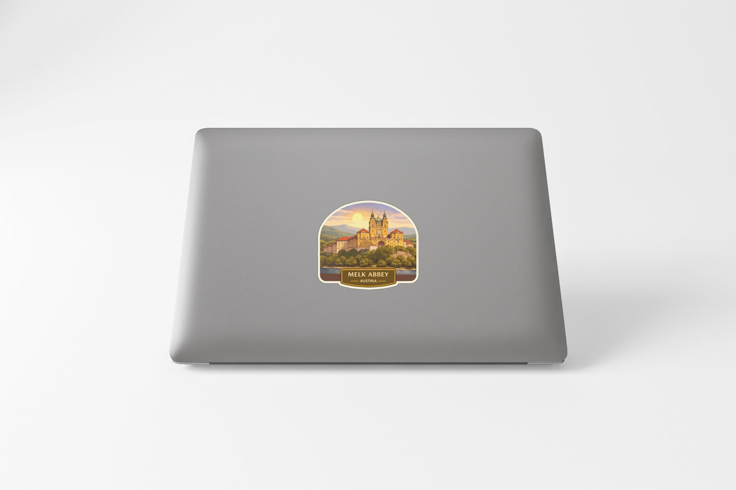 a sticker with a castle on it, placed on the back of a laptop.