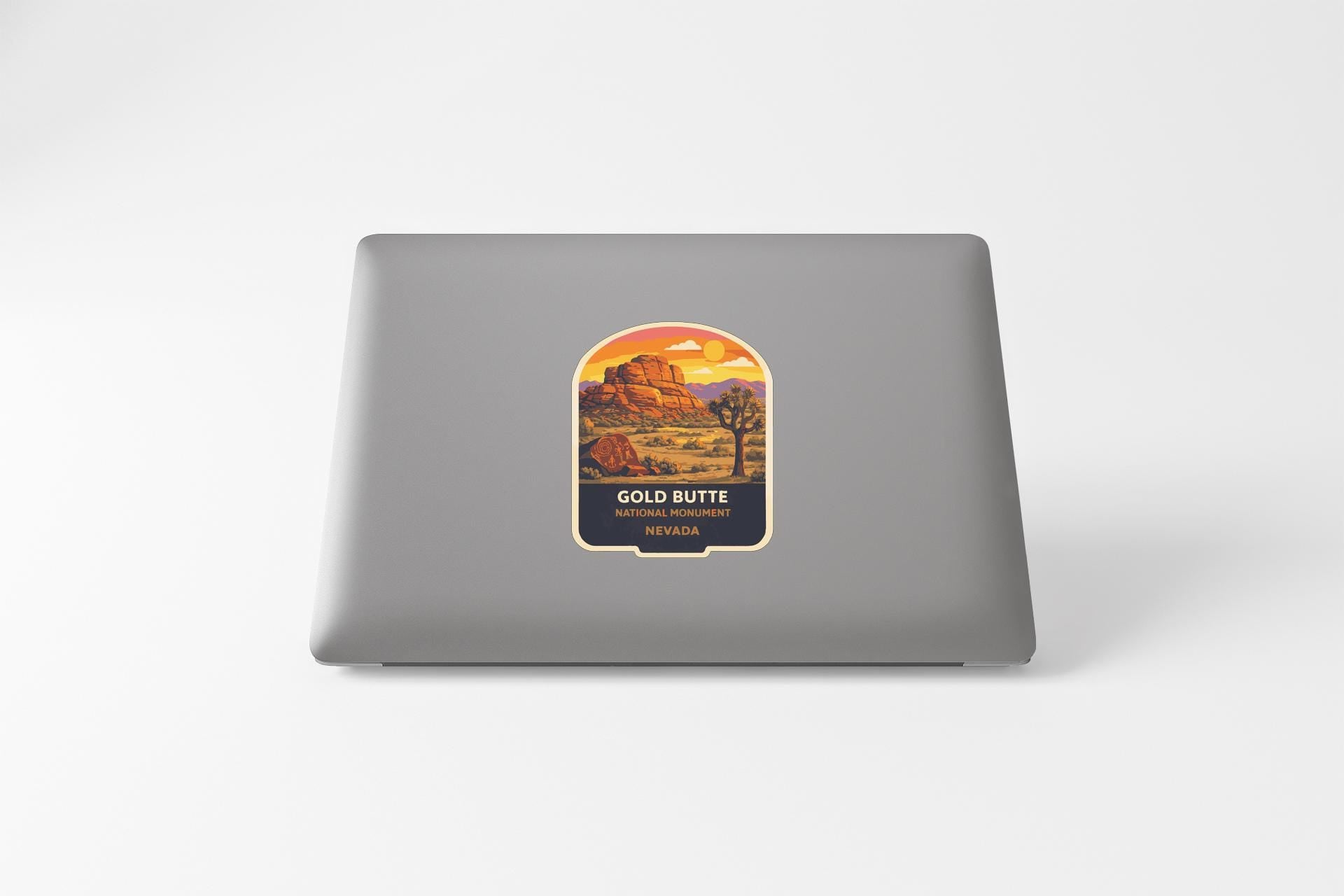 a sticker with a desert landscape and mountains on a laptop.