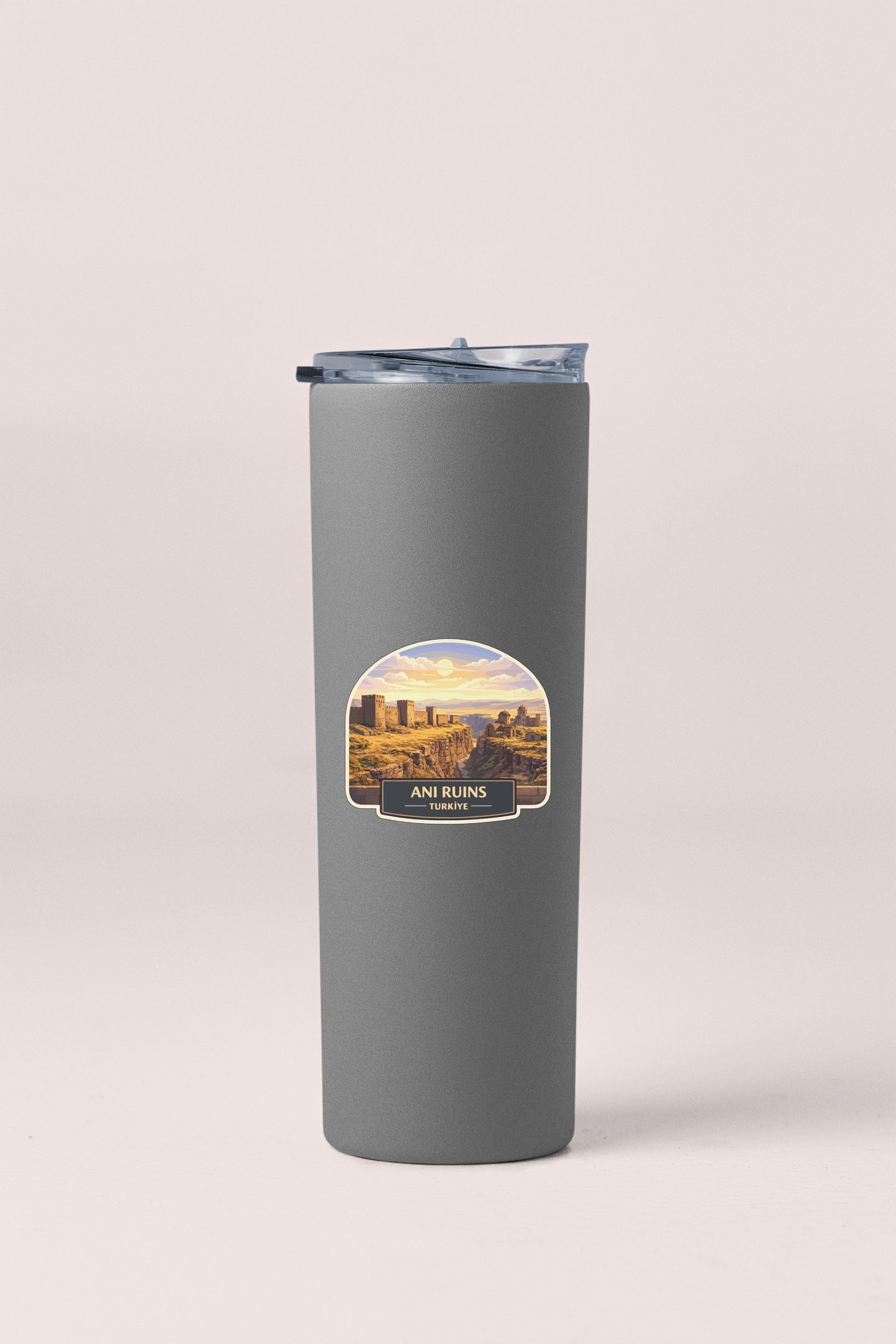 A gray insulated tumbler with a label featuring a desert landscape.