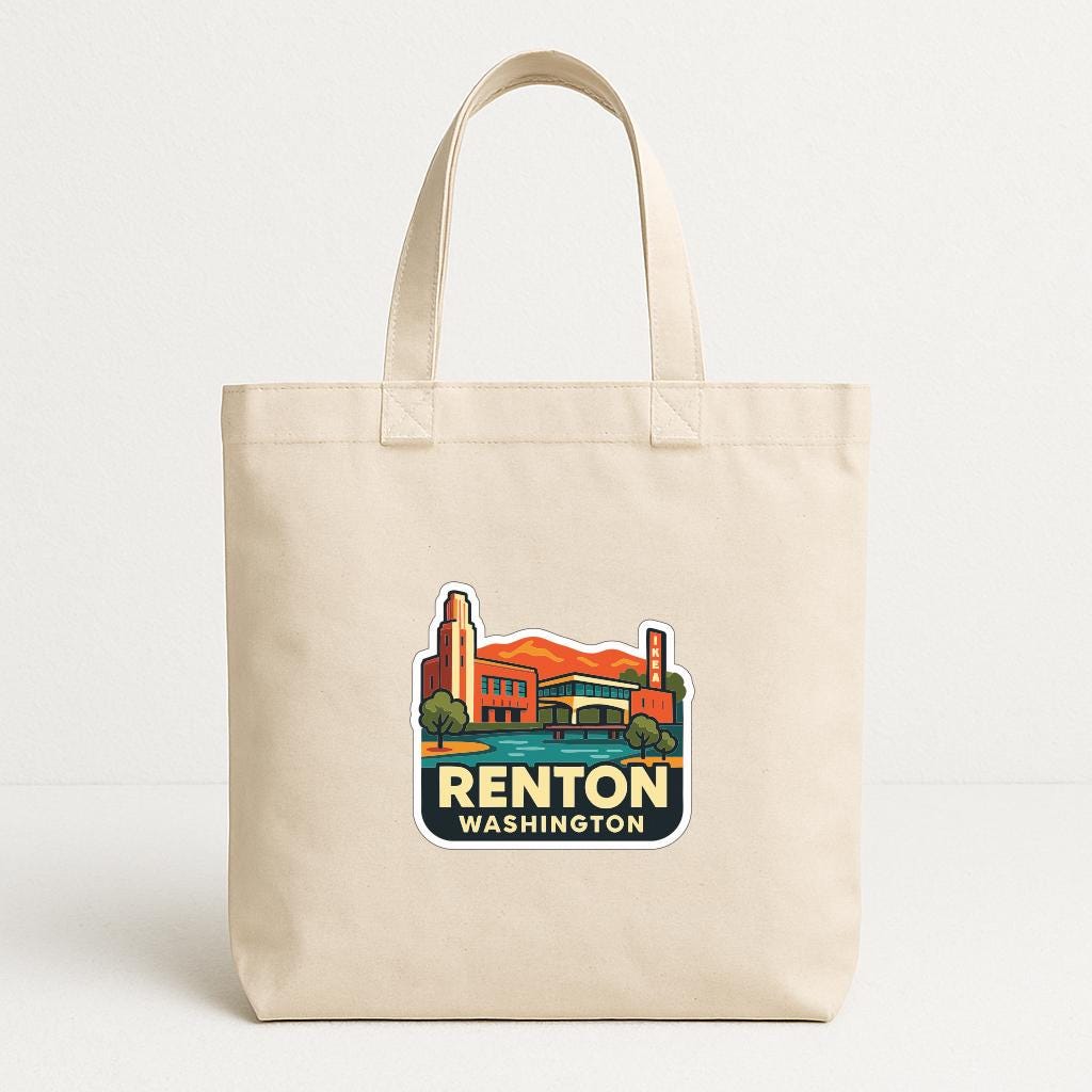 A beige tote bag with a printed sticker depicting a cityscape and the text "RENTON WASHINGTON".