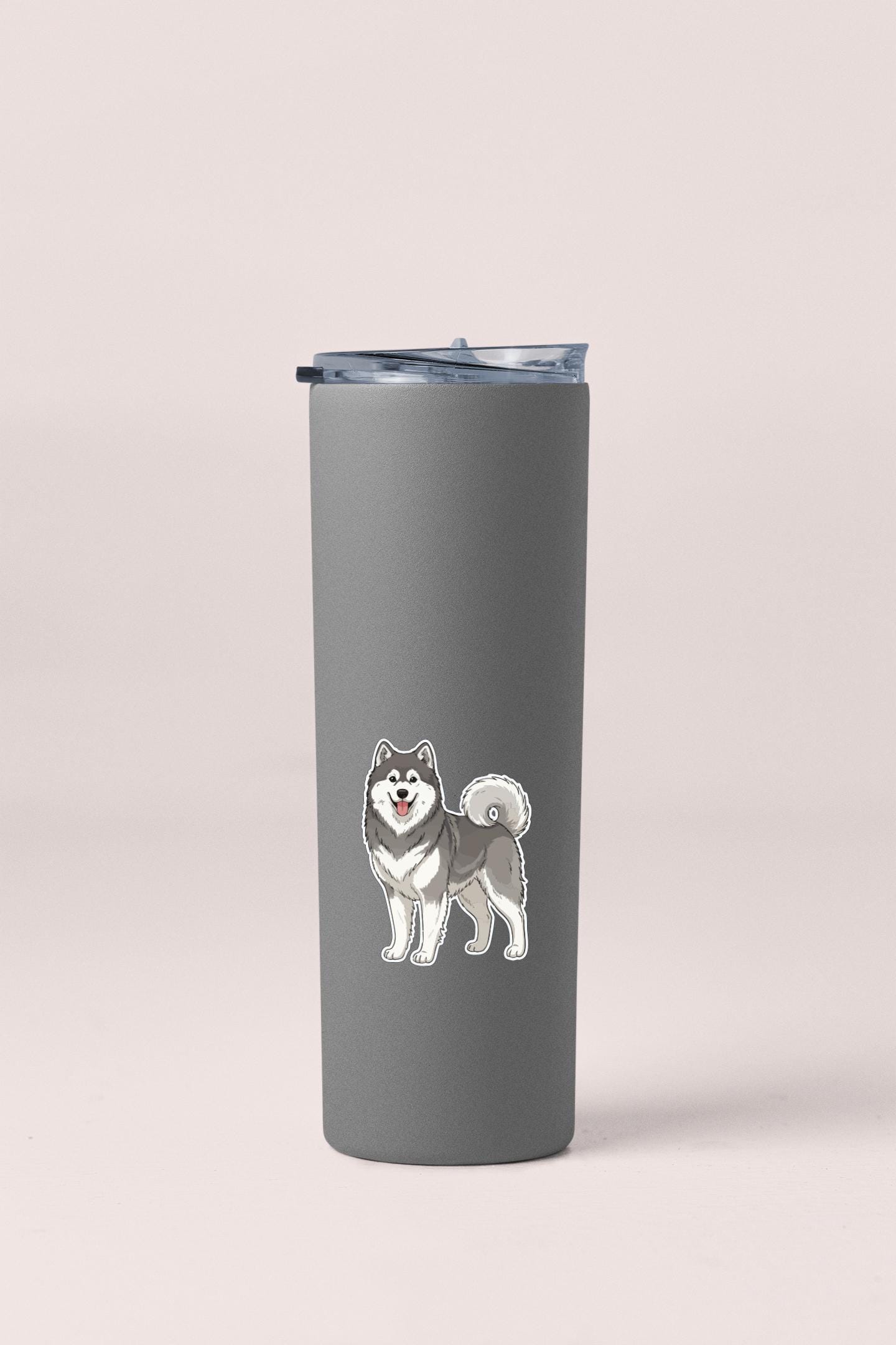 A gray insulated tumbler with a sticker of a husky dog on it.