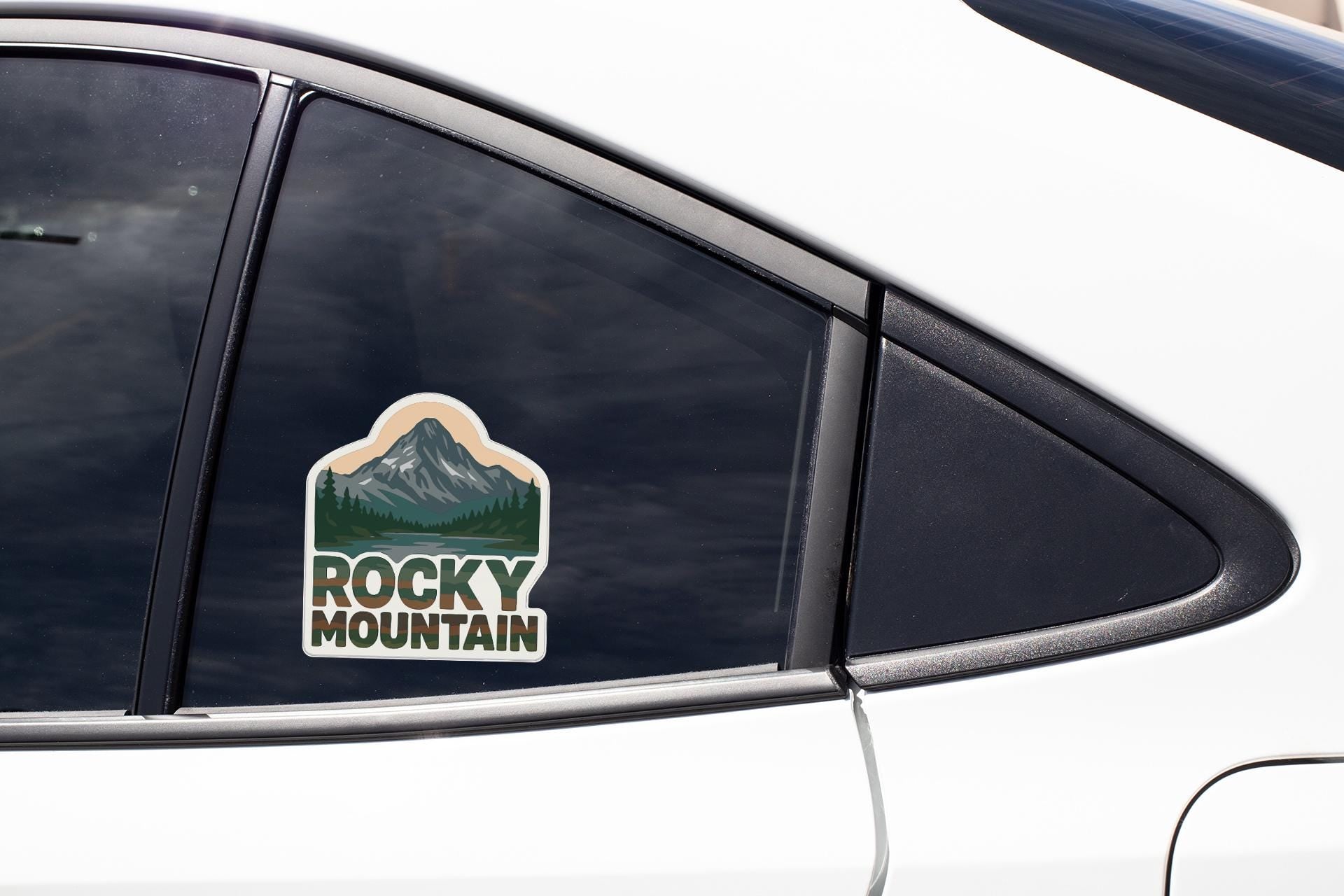 A sticker on the side of a car window that says "Rocky Mountain".
