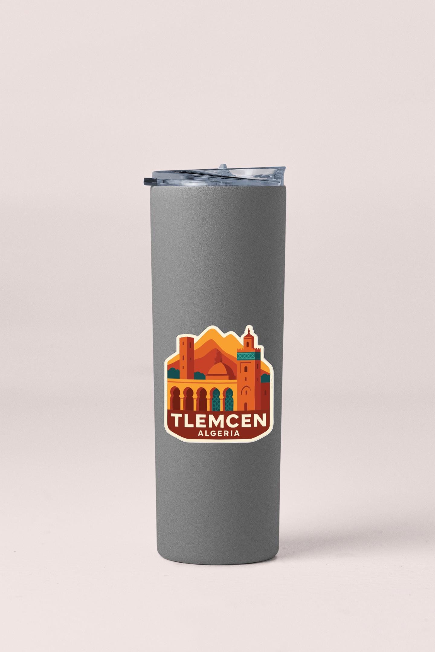 A gray insulated tumbler with a sticker depicting a cityscape and the text "TLECEN ALGERIA".