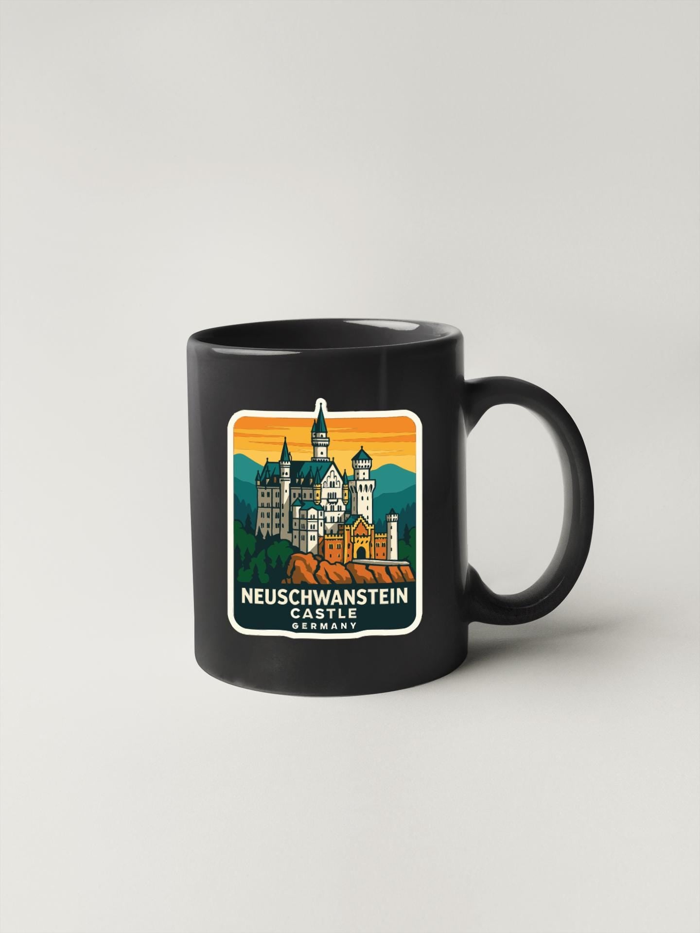 A black coffee mug with a colorful illustration of Neuschwanstein Castle in Germany.
