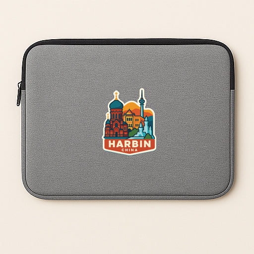 A gray laptop sleeve with a colorful sticker of Harbin, China, featuring a skyline with various landmarks.