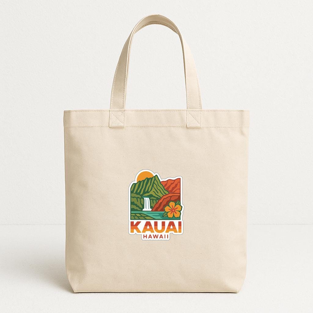 A beige tote bag with a graphic of a Hawaiian landscape and the text "KAUAI HAWAII" printed on it.