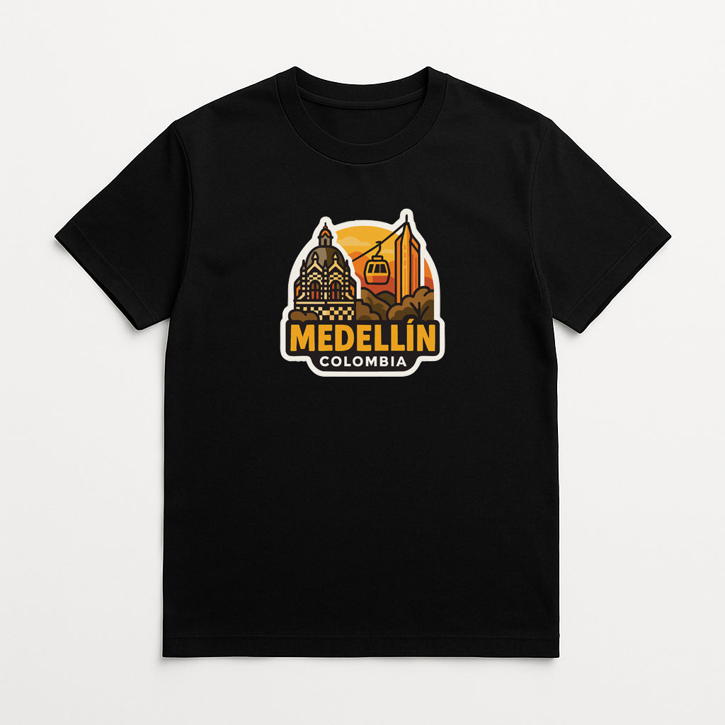 A black t-shirt with a graphic design depicting the city of Medellín, Colombia, featuring a building, a mountain, and a sunset.