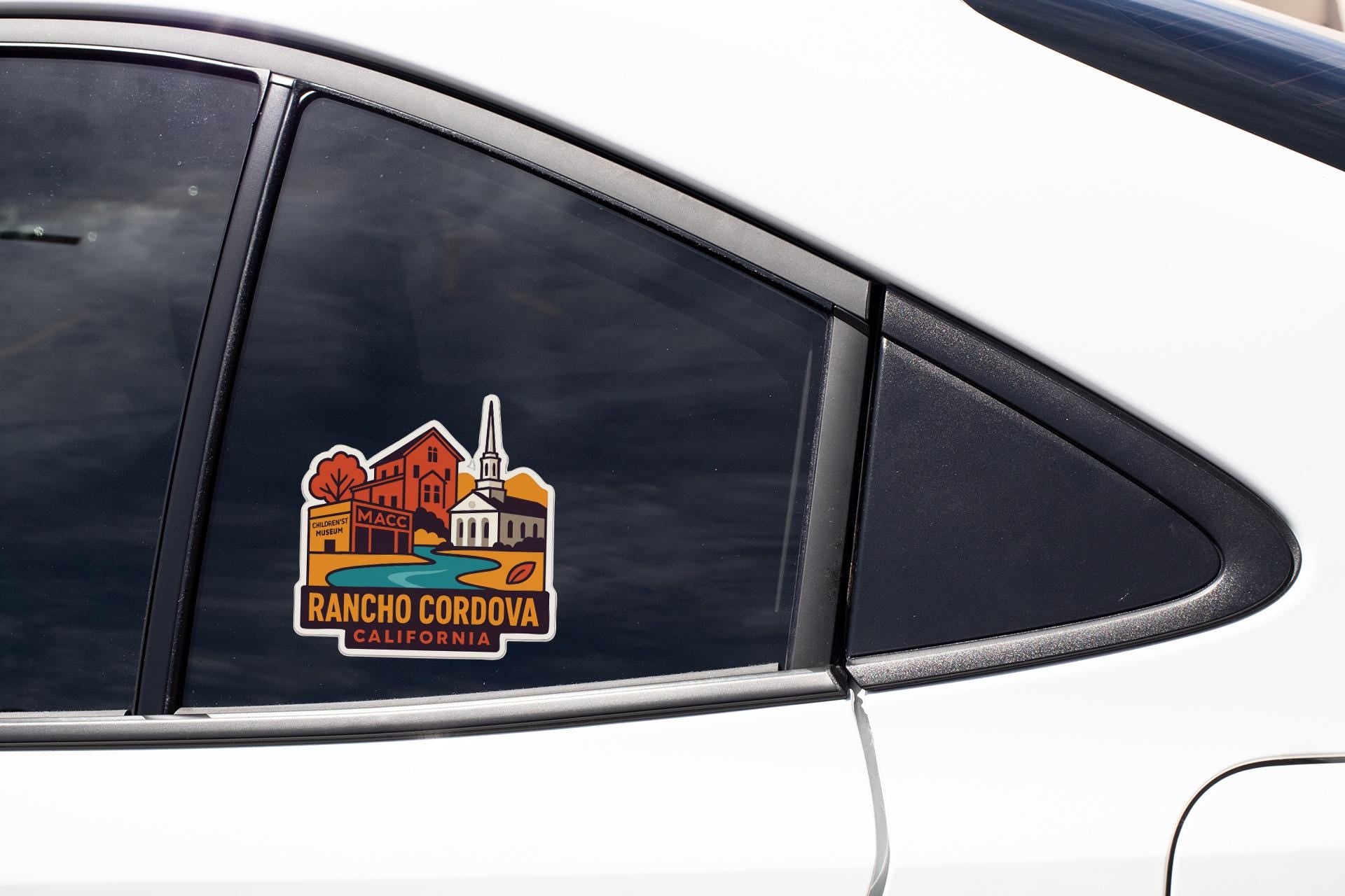 A sticker on the side of a car window, depicting a cityscape with a church and buildings, along with the text "RANCHO CORDOVA, CALIFORNIA".