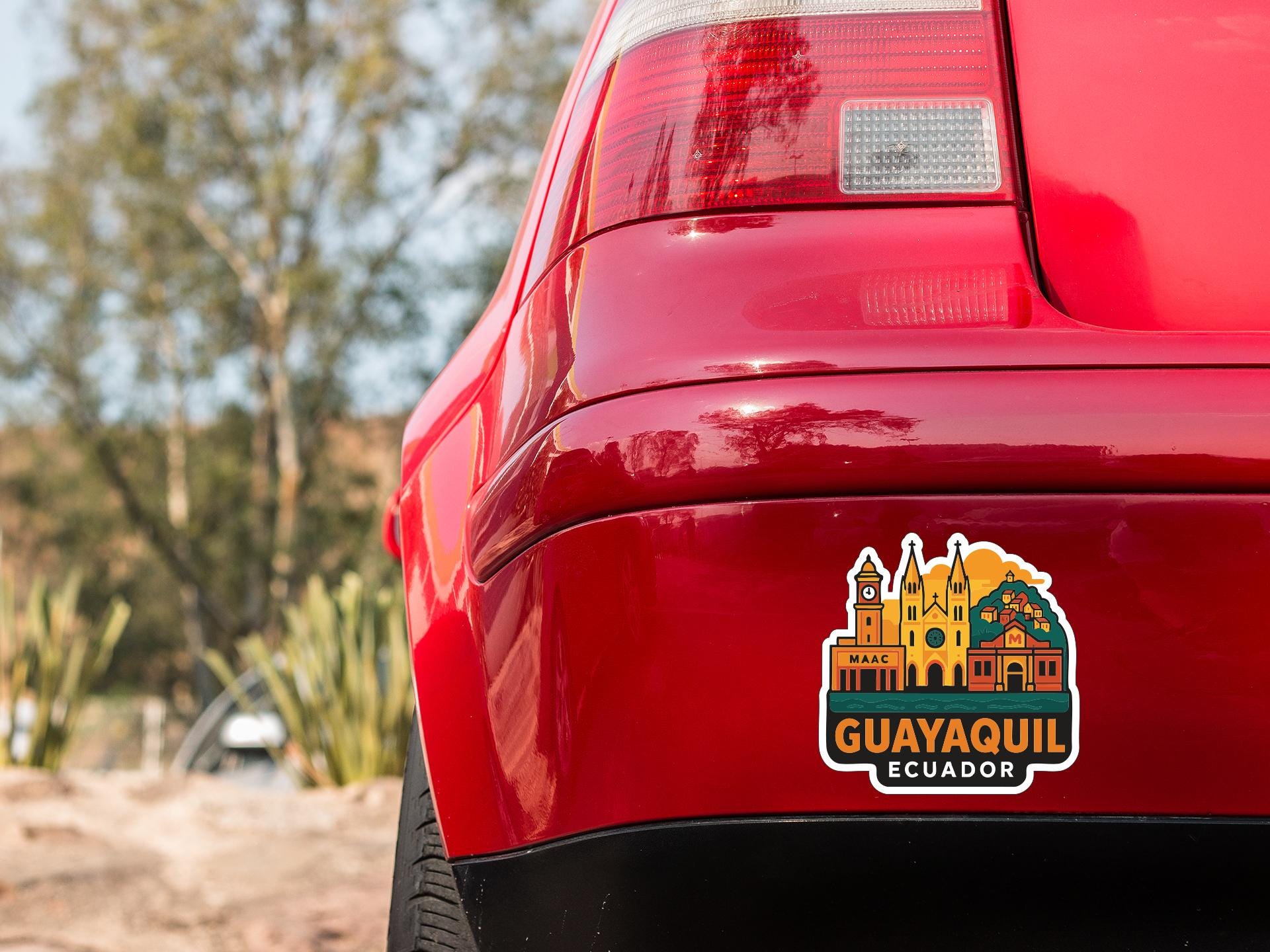 the rear end of a red car with a sticker on the trunk that displays the city of Guayaquil, Ecuador.