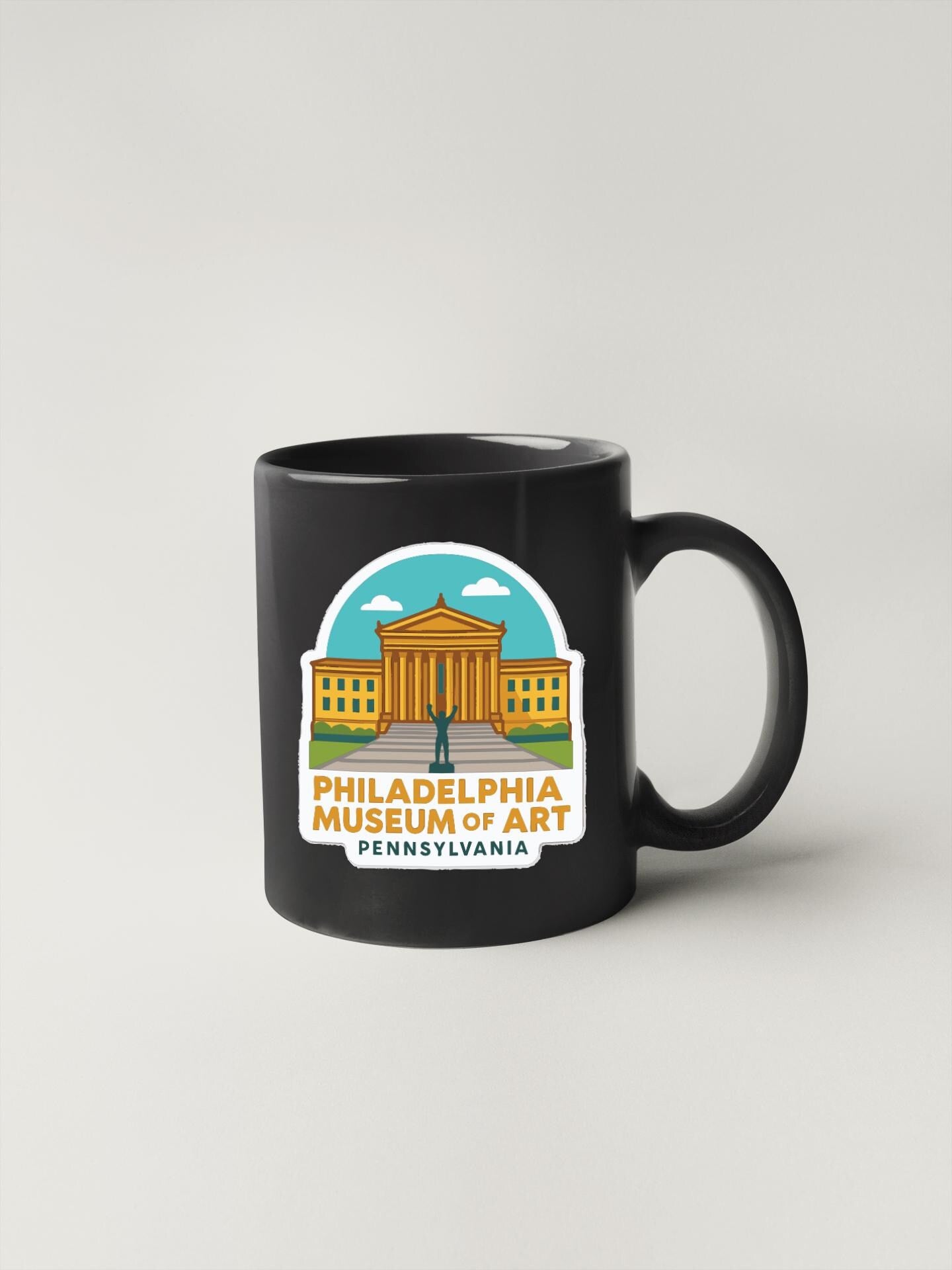 A black coffee mug with a graphic design featuring the Philadelphia Museum of Art in Pennsylvania.
