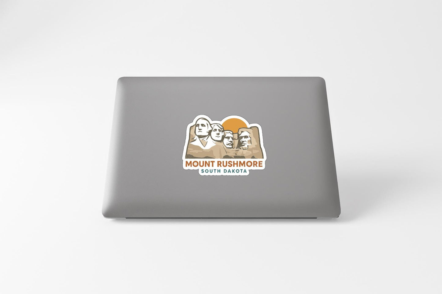 a sticker with the text "MOUNT RUSHMORE SOUTH DAKOTA" and an illustration of the iconic Mount Rushmore monument.