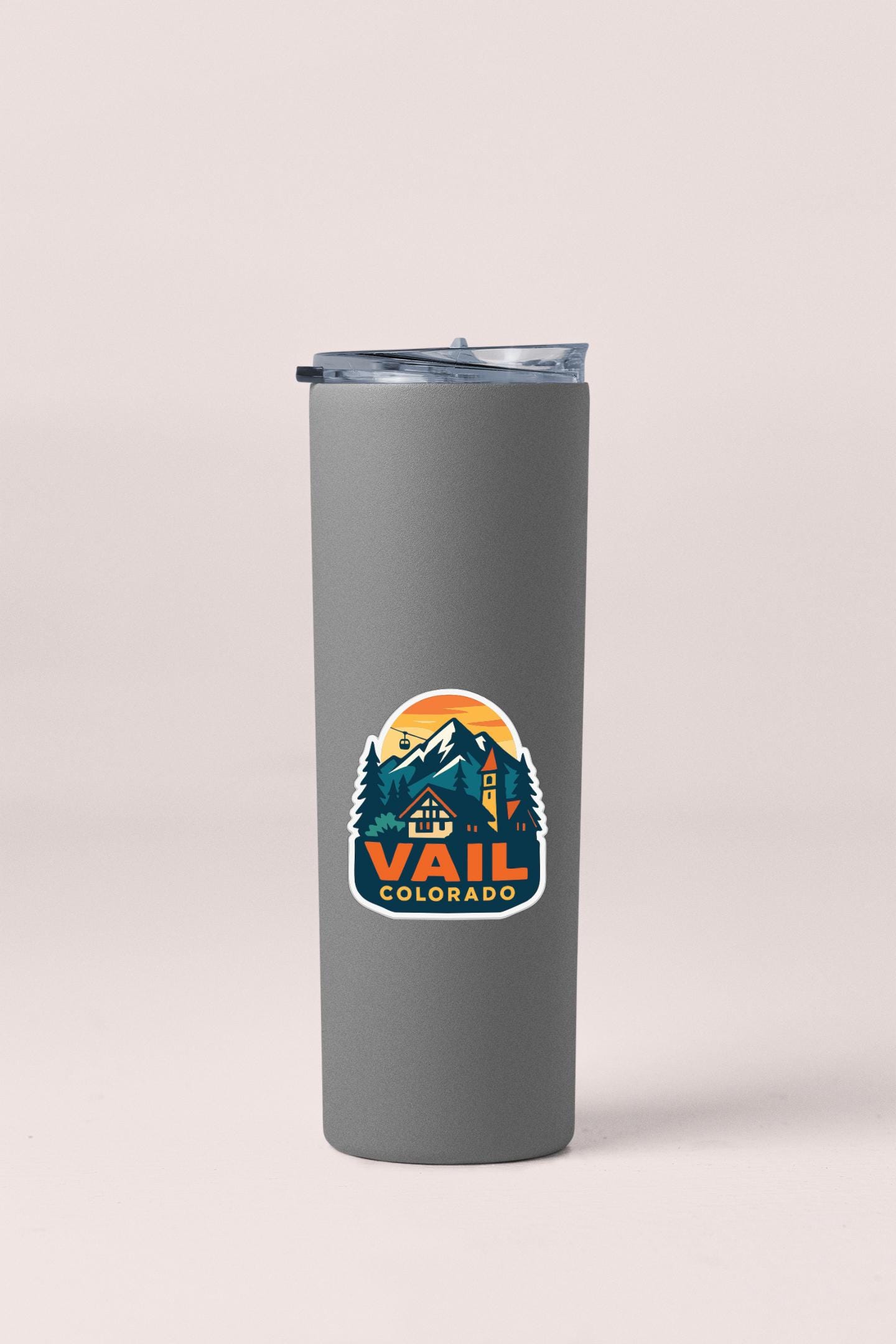 A gray insulated tumbler with a mountain landscape sticker on it.