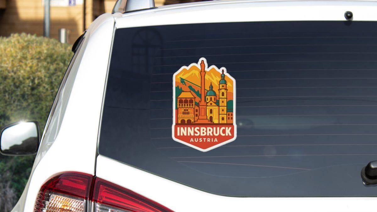 A sticker on the rear window of a car, depicting a cityscape with a tall tower and buildings, along with the text "INSBRUCK AUSTRIA".