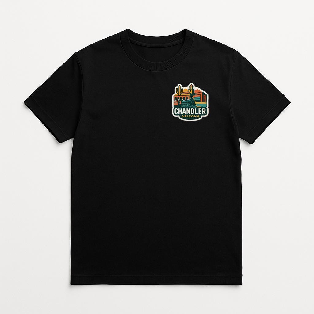 A black t-shirt with a graphic design on the front, featuring a colorful illustration of a cityscape with buildings and a prominent "CHANDLER" logo.