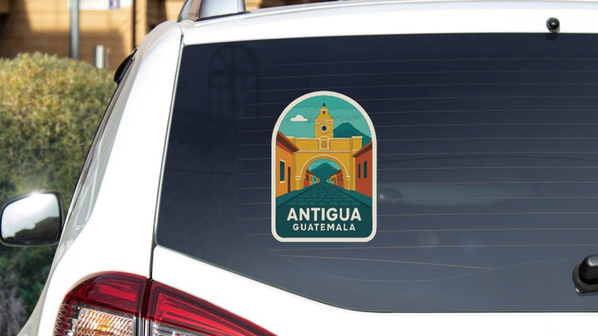 A sticker on the rear window of a white car, depicting a landmark in Guatemala.