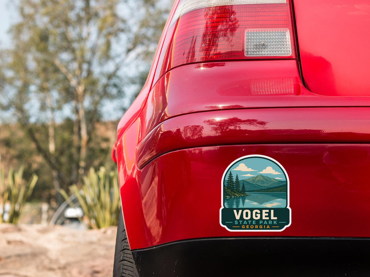 the rear end of a red car with a sticker on the trunk that says "Vogel State Park Georgia".
