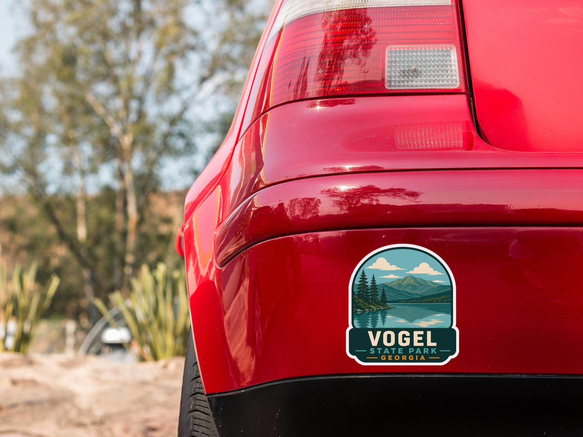 the rear end of a red car with a sticker on the trunk that says "Vogel State Park Georgia".