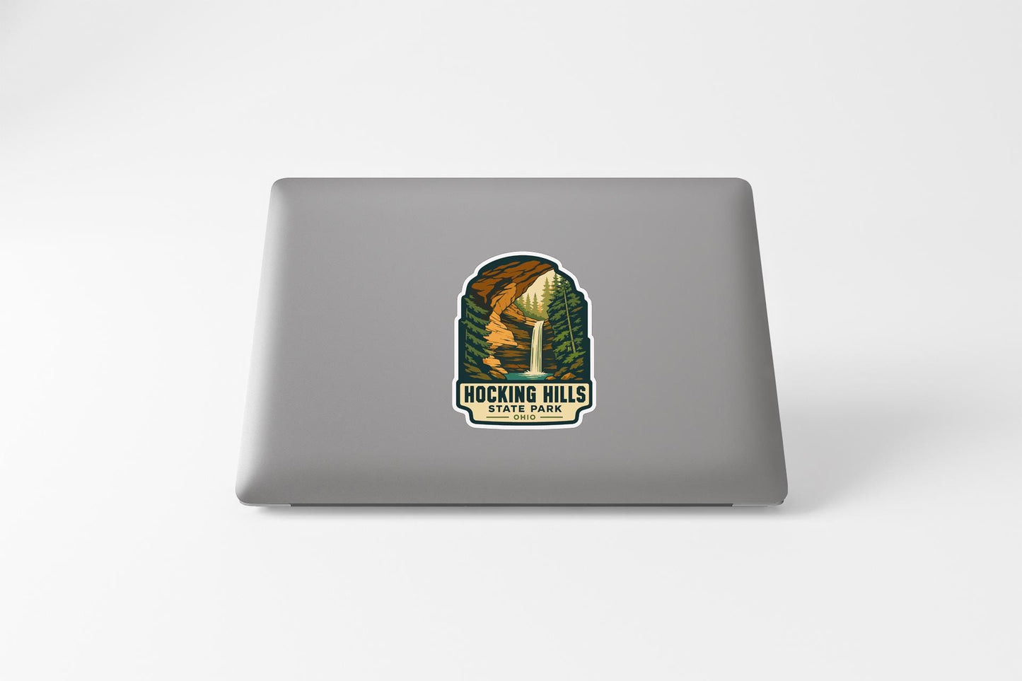 A sticker with an illustration of a waterfall and the text "Rocking Hills State Park" on a laptop.